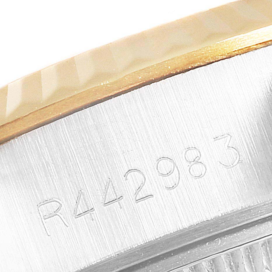 This image shows a close-up of the Rolex Datejust 69173 Women
s Steel and Gold (two tone) Champagne Dial 69173 Women
s Steel and Gold (two tone) Champagne Dial watch, focusing on the side of the bezel with engraved serial numbers.
