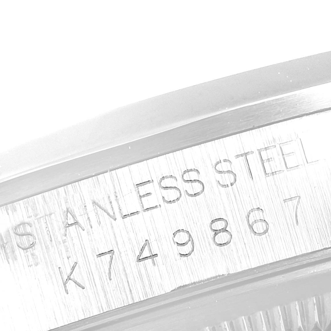 The image shows a close-up of the engraved serial number and "STAINLESS STEEL" marking on a Rolex Datejust 16200 Men's Stainless Steel White Dial 16200 Men's Stainless Steel White Dial watch case.