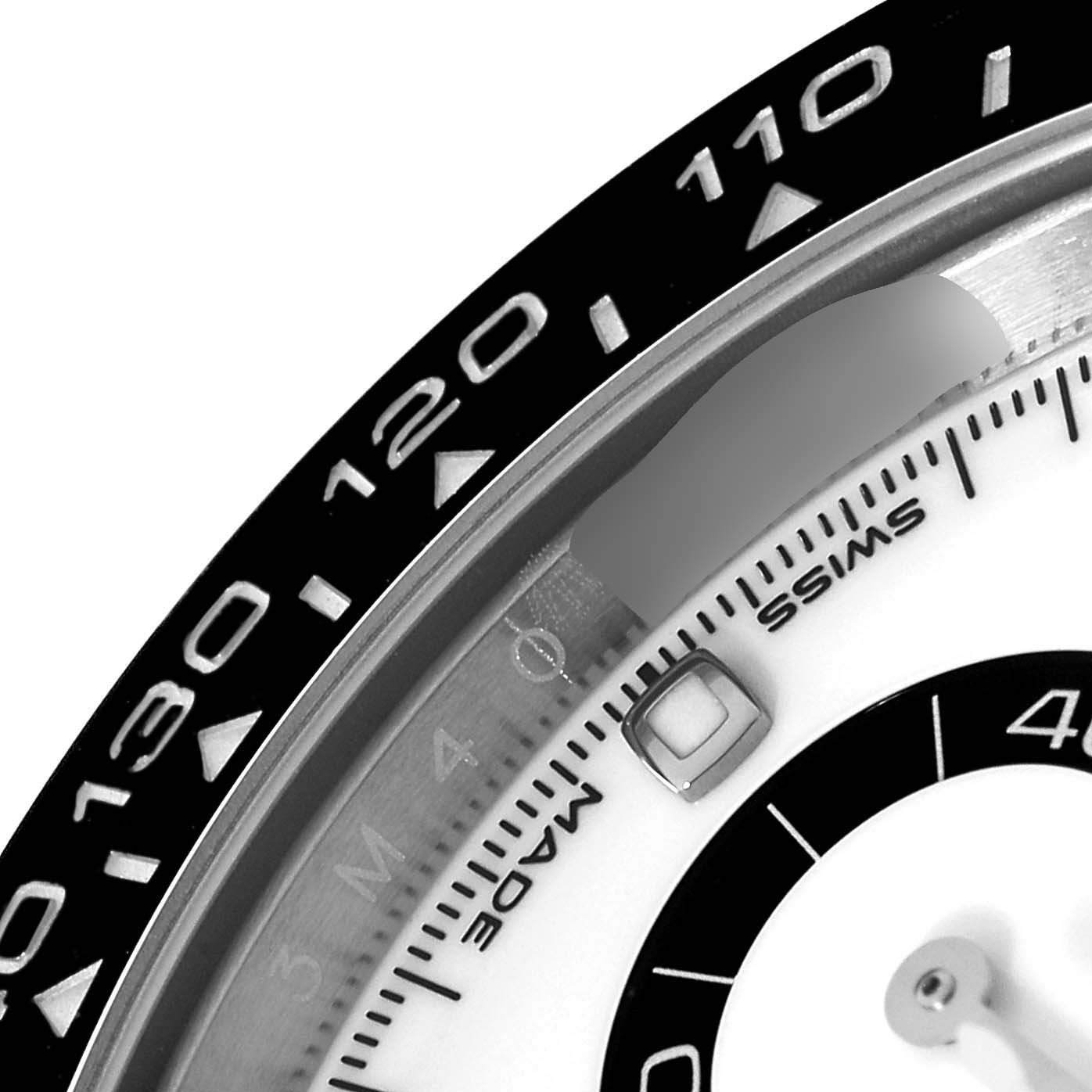 This image shows a close-up of the bezel and part of the dial of the Rolex Daytona 116500 Men's Stainless Steel White Dial 116500 Men's Stainless Steel White Dial watch.
