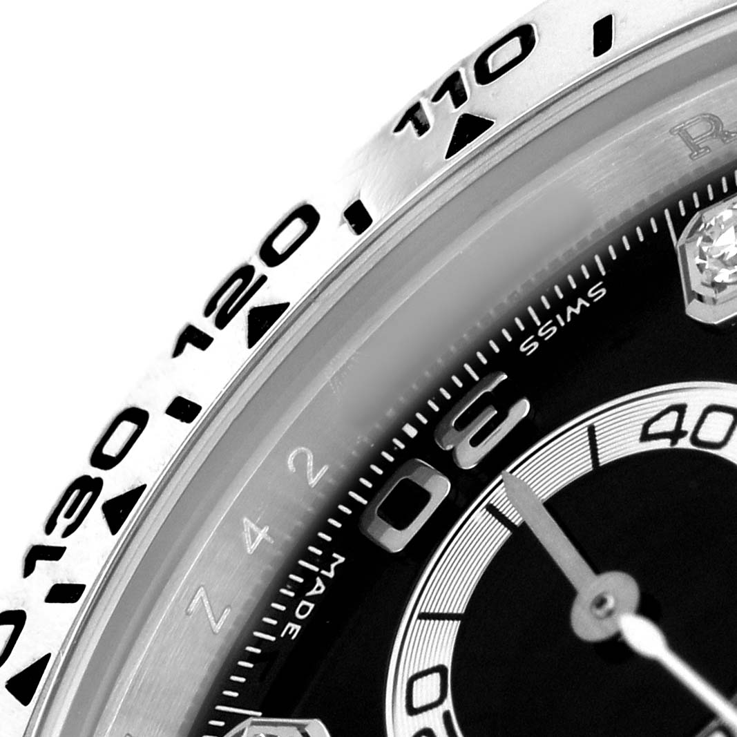 The image shows a close-up of the bezel and dial edge of a Rolex Daytona 116509 Men's White Gold Black Dial, highlighting the tachymeter scale and part of the minute markers.
