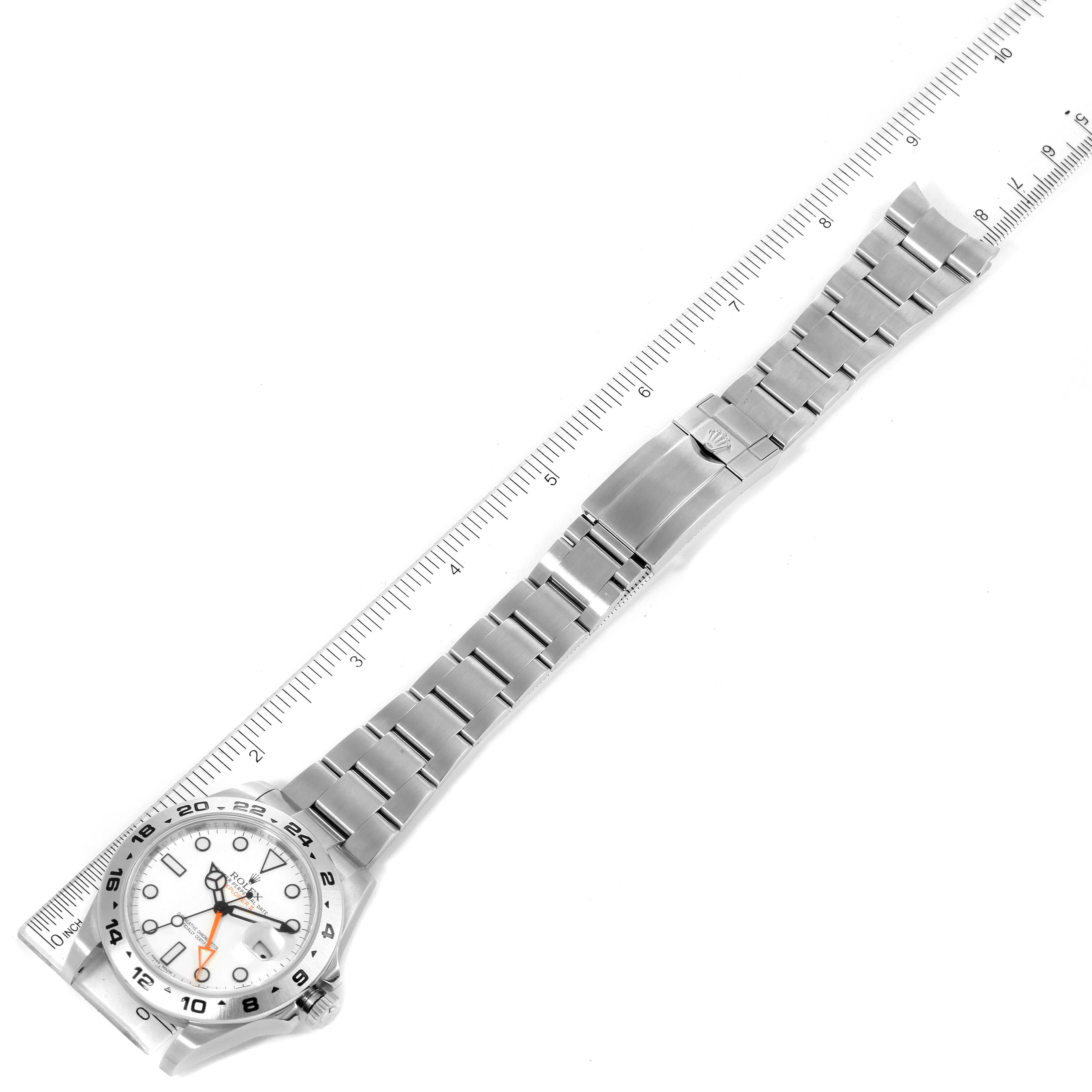 This image shows the Rolex Explorer 216570 Men's Stainless Steel White Dial 216570 Men's Stainless Steel White Dial watch from a top-down angle, displaying the face and full length of the metal bracelet alongside a ruler.