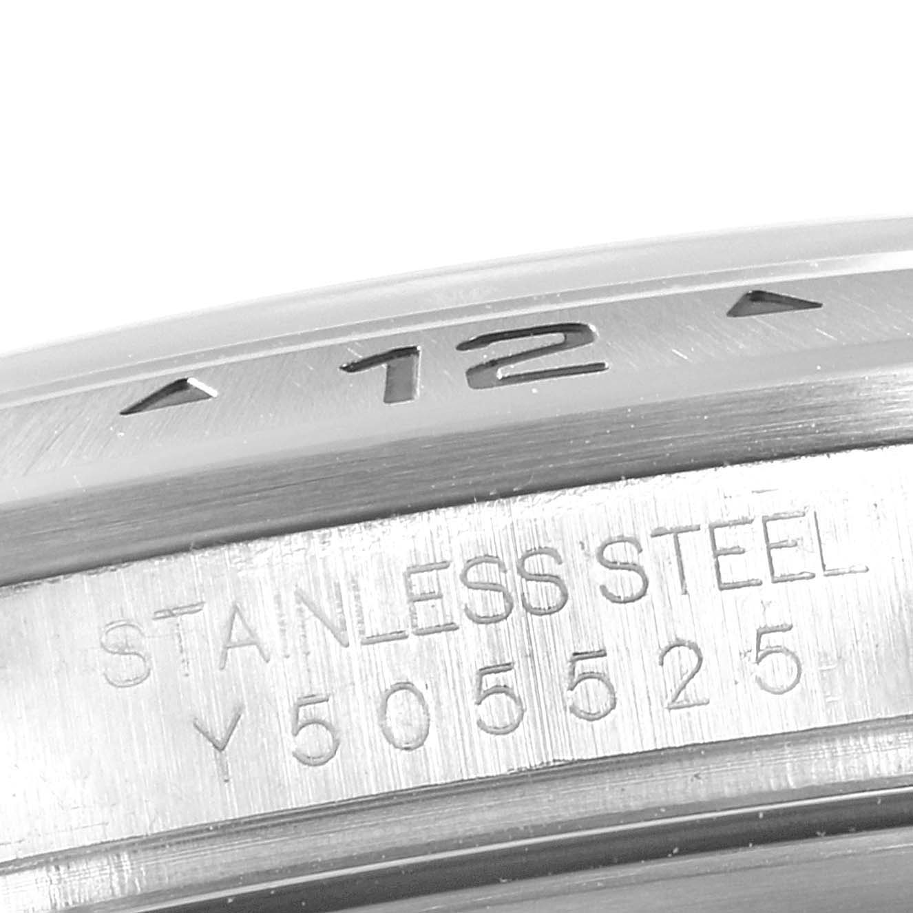 The image shows a close-up of the bezel and case of a Rolex Explorer 16570 Men
s Stainless Steel White Dial 16570 Men
s Stainless Steel White Dial watch, highlighting the "12" marker and "Stainless Steel" engraving.