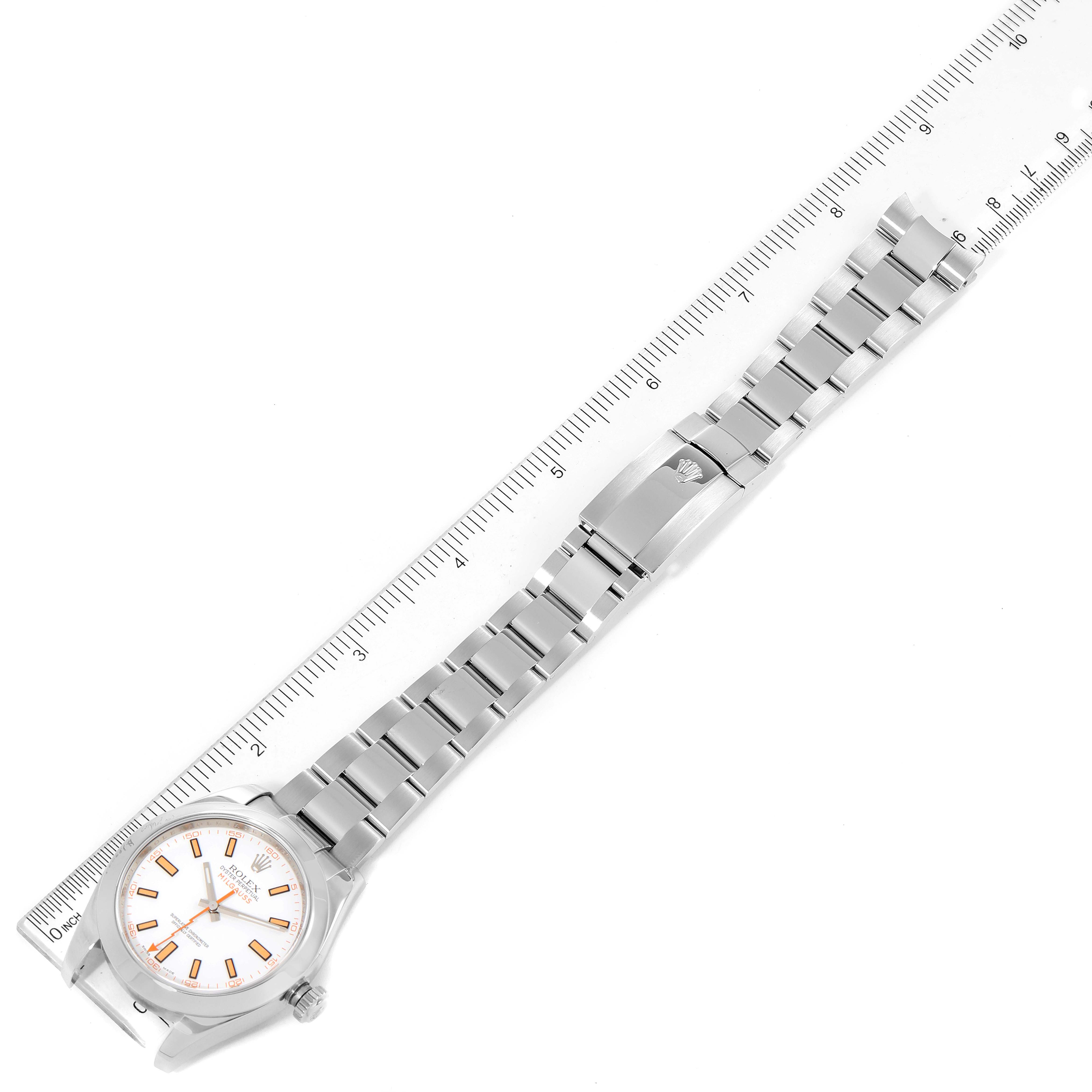 The Rolex Milgauss 116400V Men's Stainless Steel White Dial 116400V Men's Stainless Steel White Dial watch is shown in a top-down angle with its full metal bracelet and clasp, placed next to a ruler for size reference.