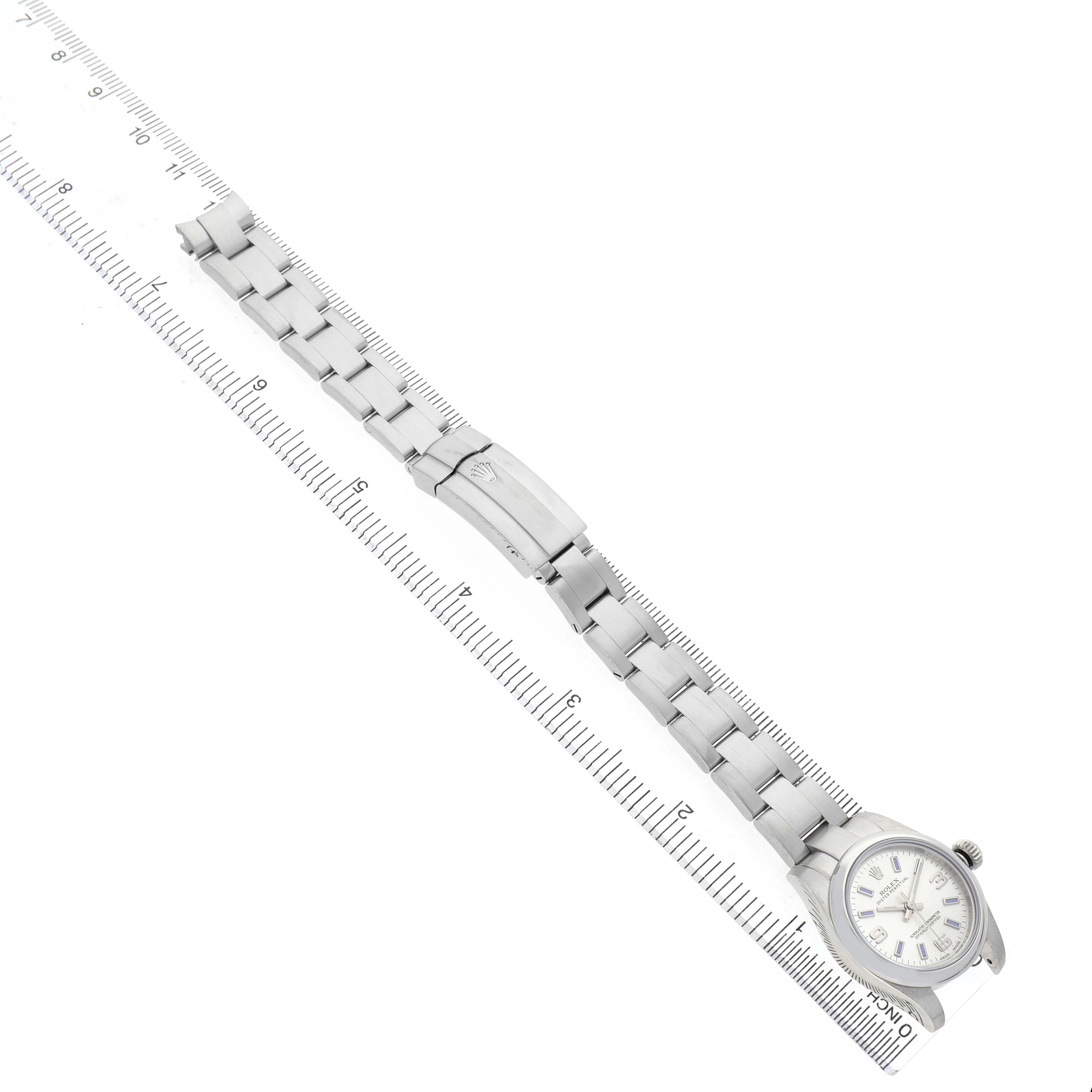 The Rolex Oyster Perpetual 176200 Women's Stainless Steel Silver Dial is shown from above, displaying the full bracelet, clasp, and watch face adjacent to a ruler.