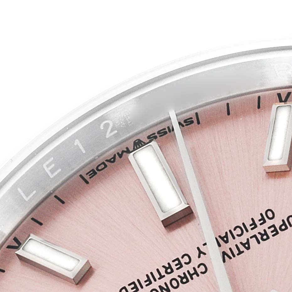 This close-up image shows the upper-left portion of the dial of a Rolex Oyster Perpetual 124200 Men
s Stainless Steel Pink Dial 124200 Men
s Stainless Steel Pink Dial watch, featuring markers, part of the bezel, and text.