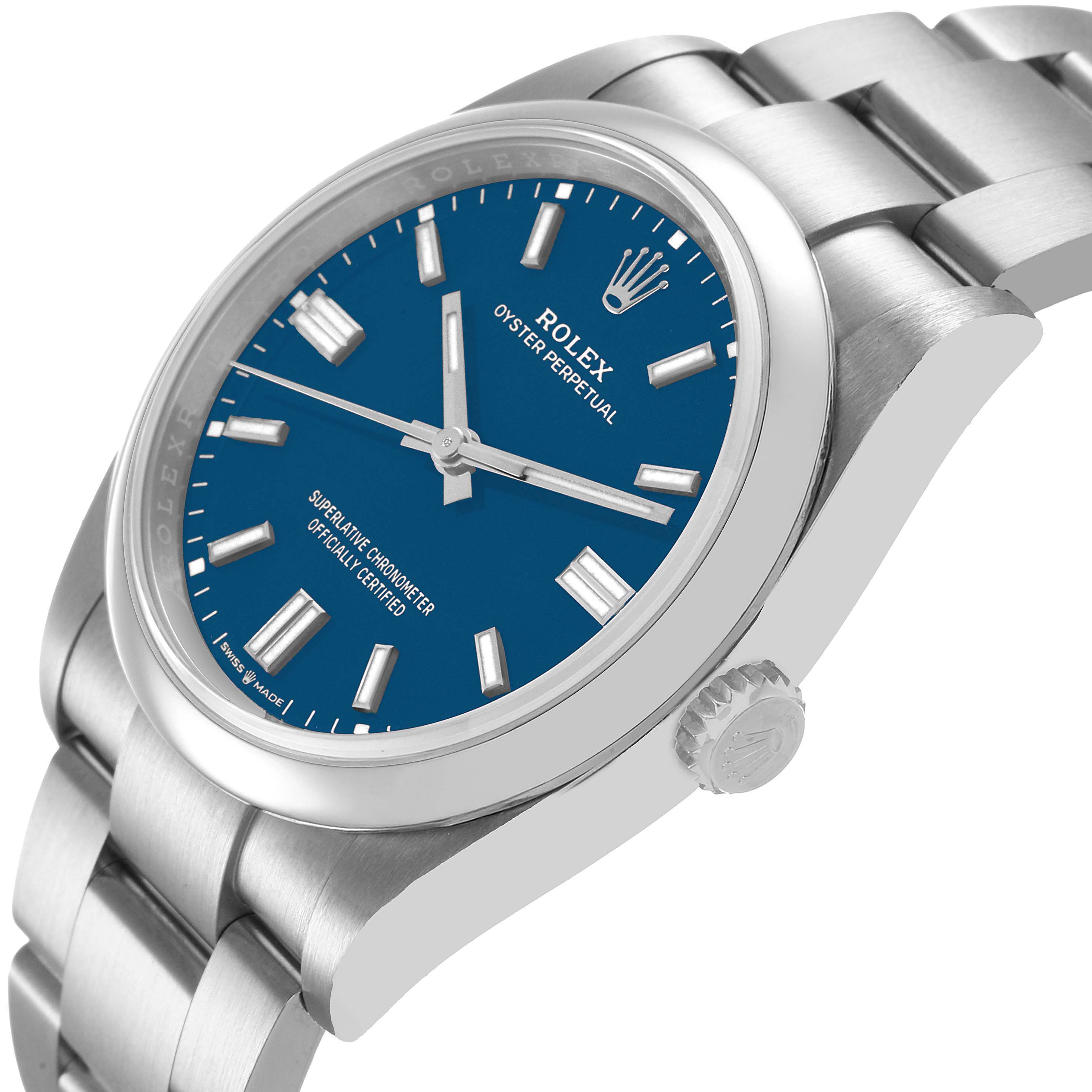 The Rolex Oyster Perpetual 126000 Men's Stainless Steel Blue Dial watch is shown at an angle highlighting its blue dial, stainless steel bracelet, bezel, and crown.