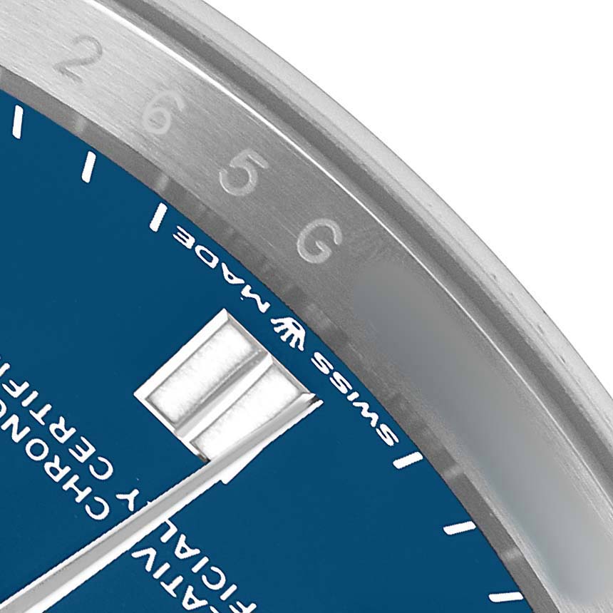 The image shows a close-up of the Rolex Oyster Perpetual 126000 Men's Stainless Steel Blue Dial watch face, highlighting the edge with markings and the "Swiss Made" text.