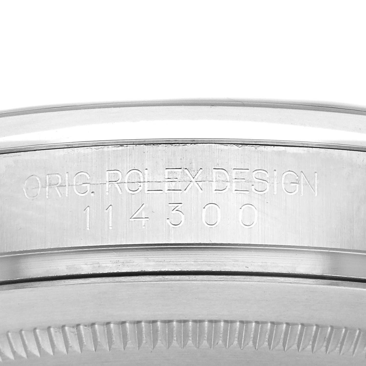 The image shows a close-up of the side view of a Rolex Oyster Perpetual 114300 Men
s Stainless Steel Black Dial 114300 Men
s Stainless Steel Black Dial model
s case, displaying its engraved design number.