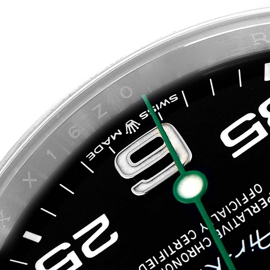 The image shows a close-up of the dial on the Rolex Air-King 126900 Men
s Stainless Steel Black Dial 126900 Men
s Stainless Steel Black Dial, highlighting the 9 o
clock numeral and the green second hand.