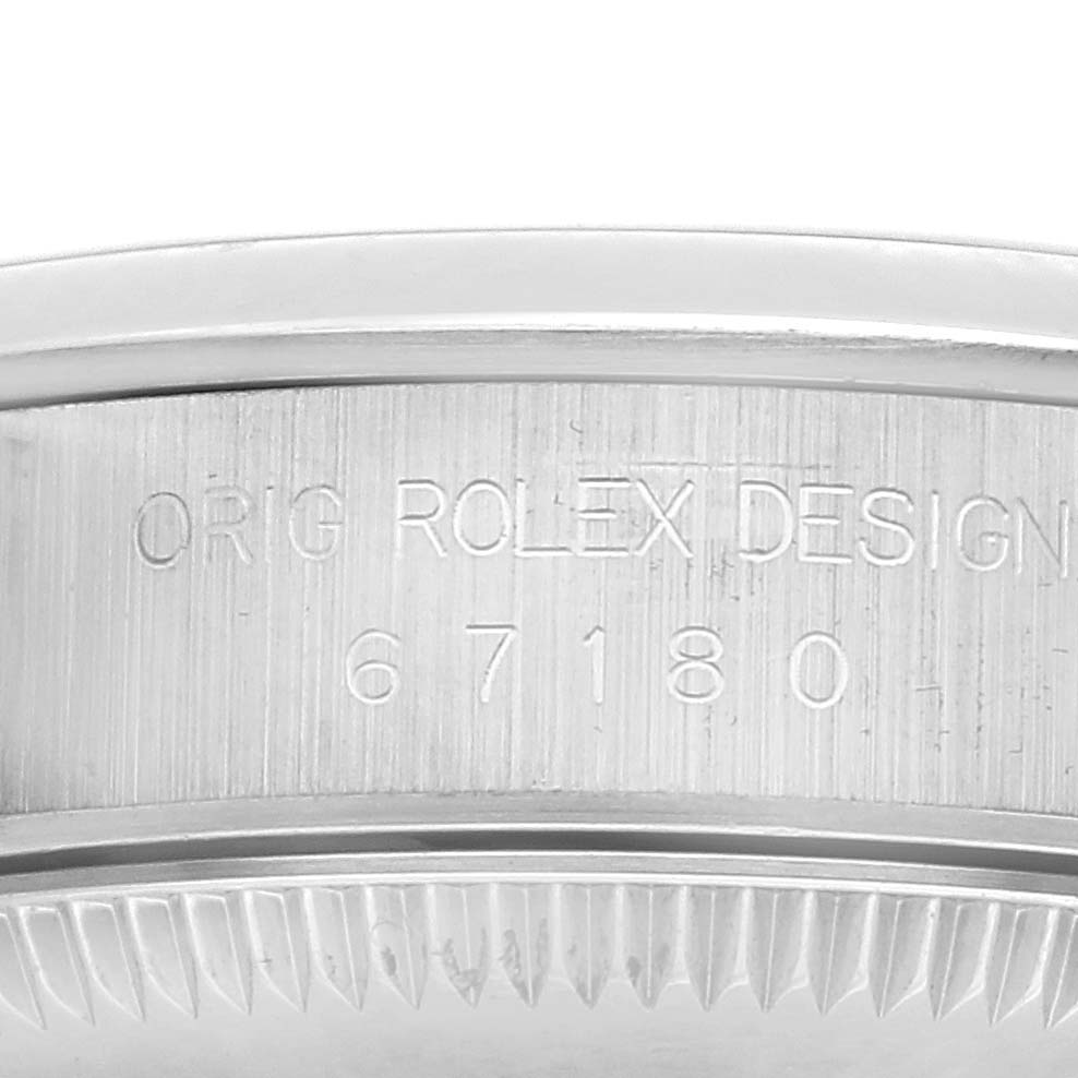 The image shows a close-up of the side of a Rolex Oyster Perpetual 67180 Women
s Stainless Steel Black Dial 67180 Women
s Stainless Steel Black Dial, featuring its engraved reference number.