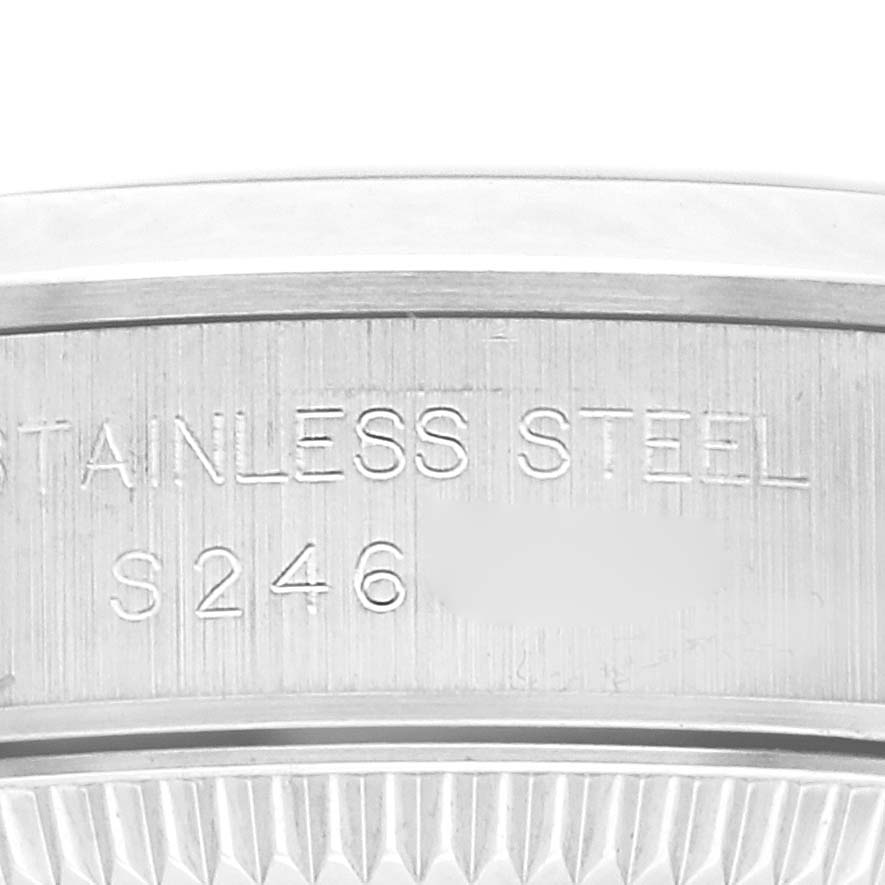 The image shows a close-up of the engraved stainless steel edge of a Rolex Oyster Perpetual 67180 Women
s Stainless Steel Black Dial 67180 Women
s Stainless Steel Black Dial watch.