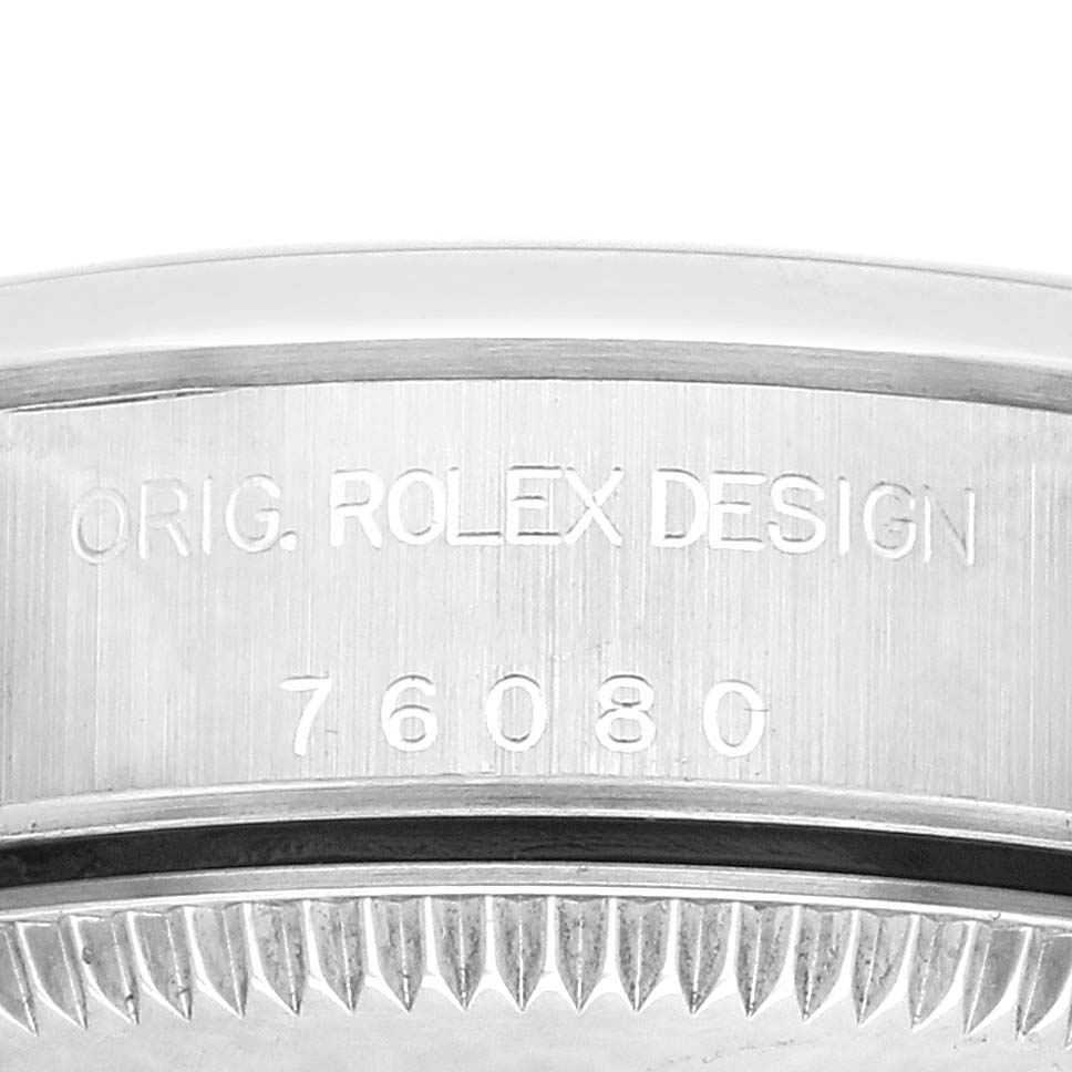 The image shows an engraving on the side of a Rolex Oyster Perpetual 76080 Women
s Stainless Steel Blue Dial 76080 Women
s Stainless Steel Blue Dial, focusing on the case design and reference number.