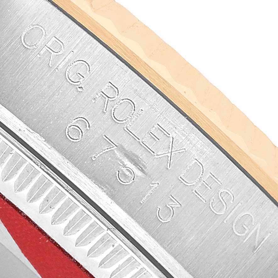 The image shows a close-up of the bezel edge and case side of the Rolex Oyster Perpetual 67513 Women's Steel and Gold (two tone) White Dial, highlighting engraved details.