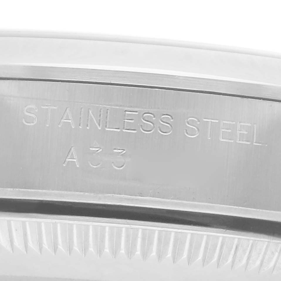 The image shows a close-up of the stainless steel bezel with engravings on the Rolex Oyster Perpetual 76080 Women
s Stainless Steel Silver Dial 76080 Women
s Stainless Steel Silver Dial watch.