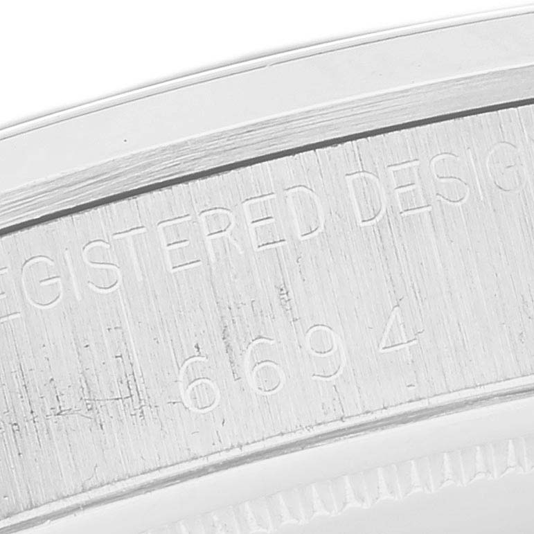 This close-up image shows the engraved serial number and design registration on the side of the Rolex Vintage Collection 6694 Men's Stainless Steel Silver Dial 6694 Men's Stainless Steel Silver Dial model.