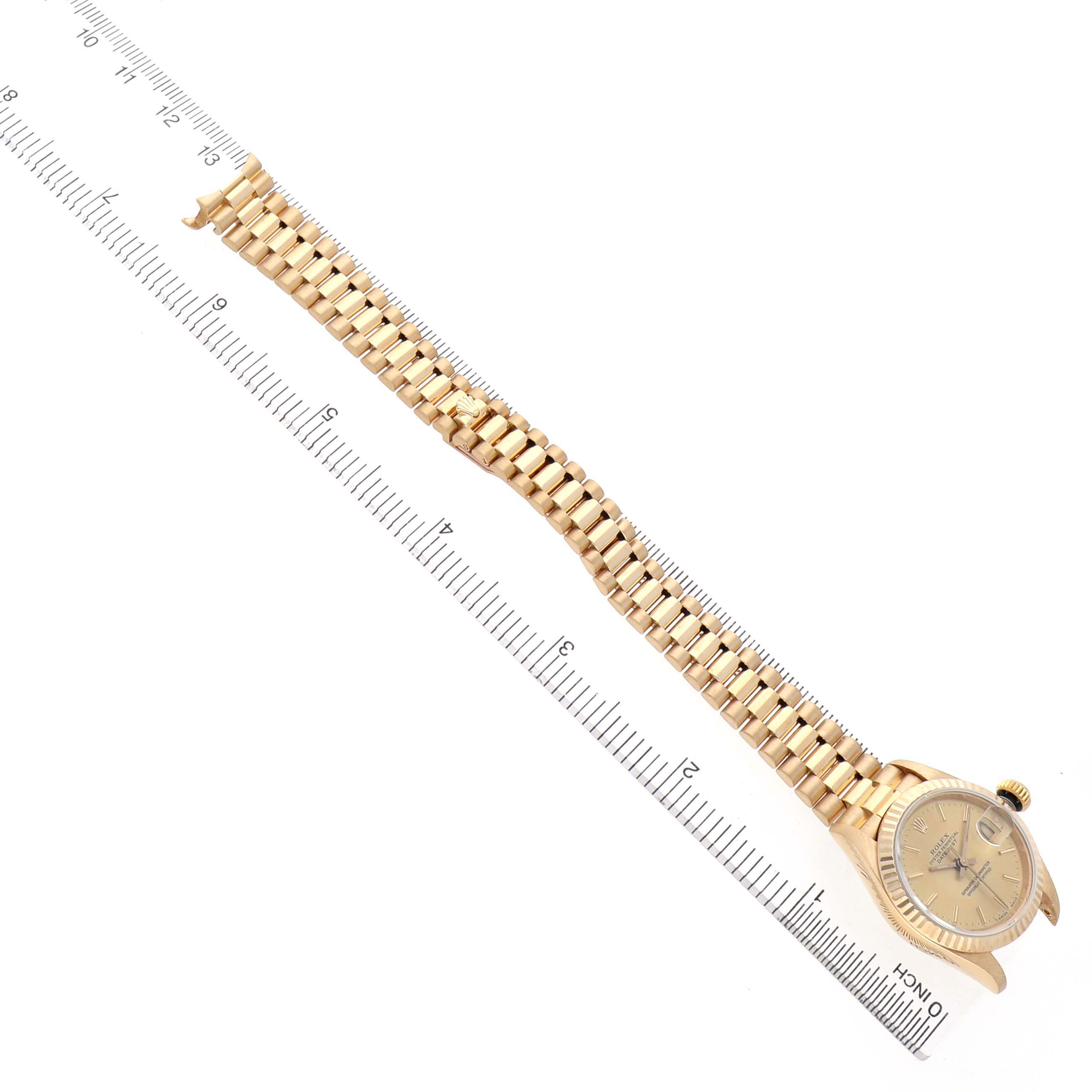 The image shows a Rolex President 69178 Women's Yellow Gold Champagne Dial watch from a top-down angle, highlighting its bracelet and face next to a ruler for scale.
