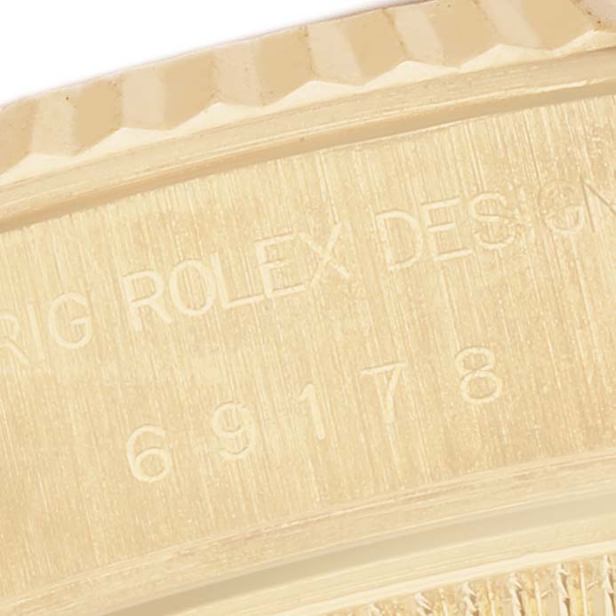 The image shows a close-up of the side of the Rolex President 69178 Women's Yellow Gold Champagne Dial watch, featuring engraved text and model number.