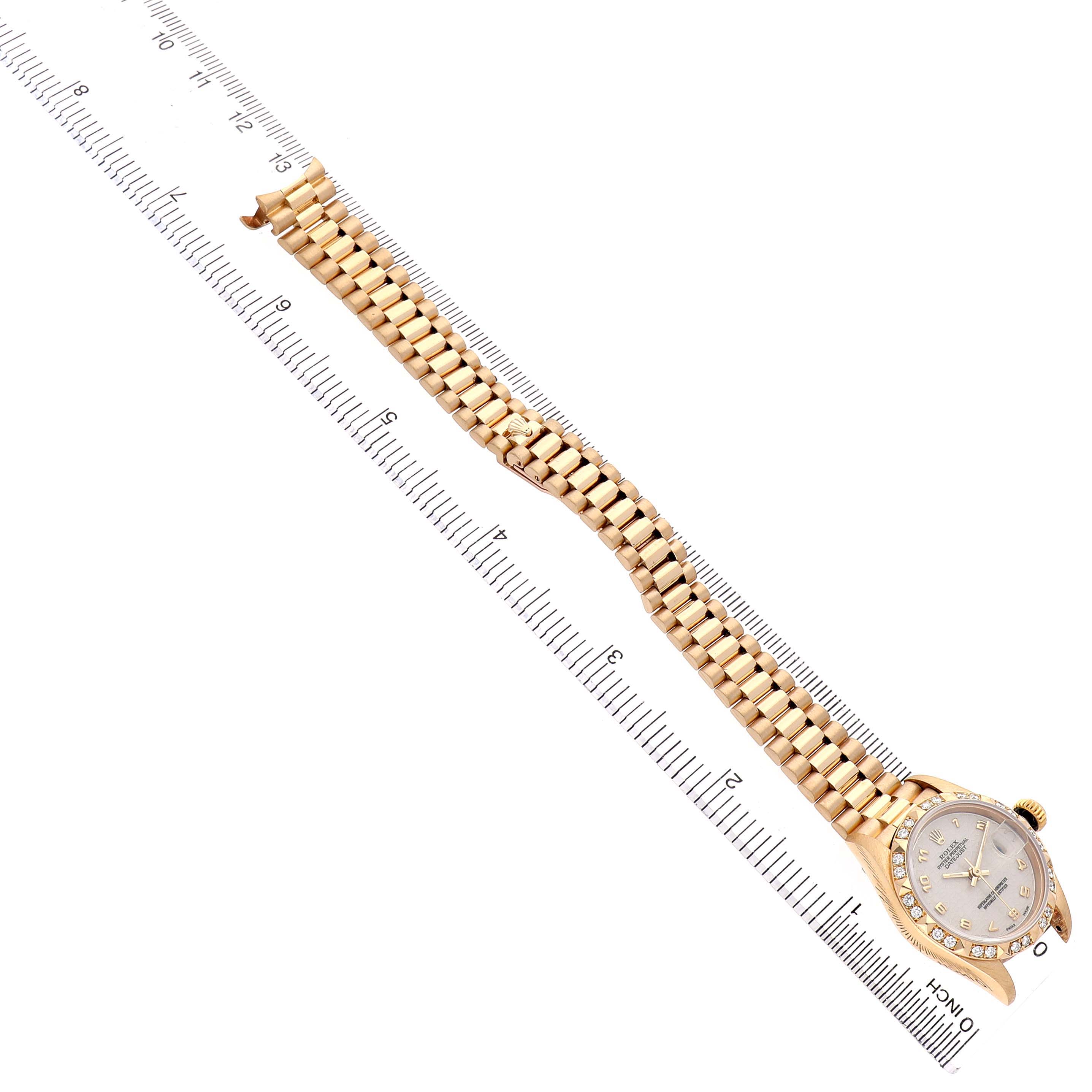 The image shows a Rolex President 69258 Women's Yellow Gold White Dial model laid flat with the face and bracelet displayed on a ruler.