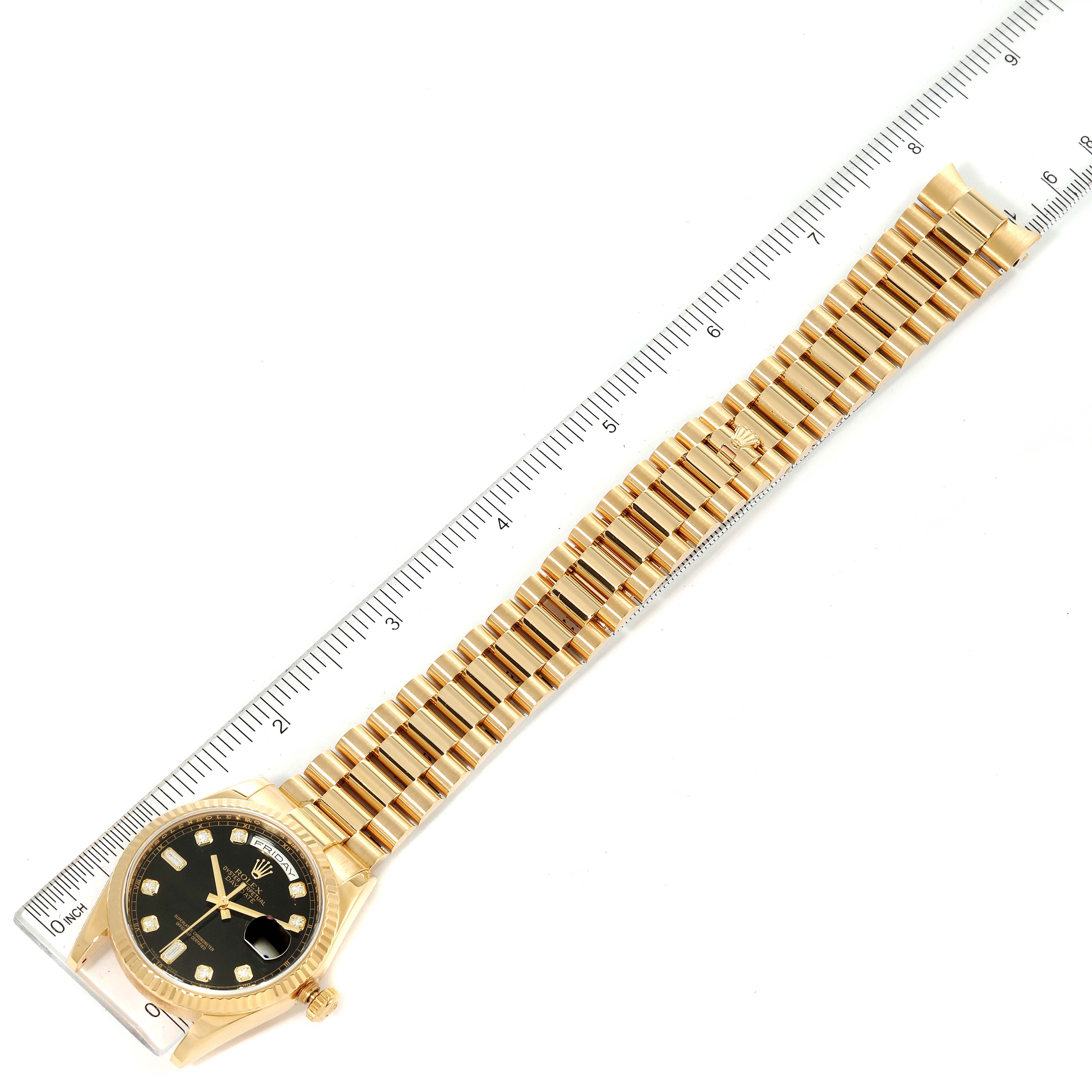 The image shows a Rolex President 118238 Men's Yellow Gold Black Dial 118238 Men's Yellow Gold Black Dial model watch from an overhead angle, displaying its gold bracelet and black dial with a ruler for scale.