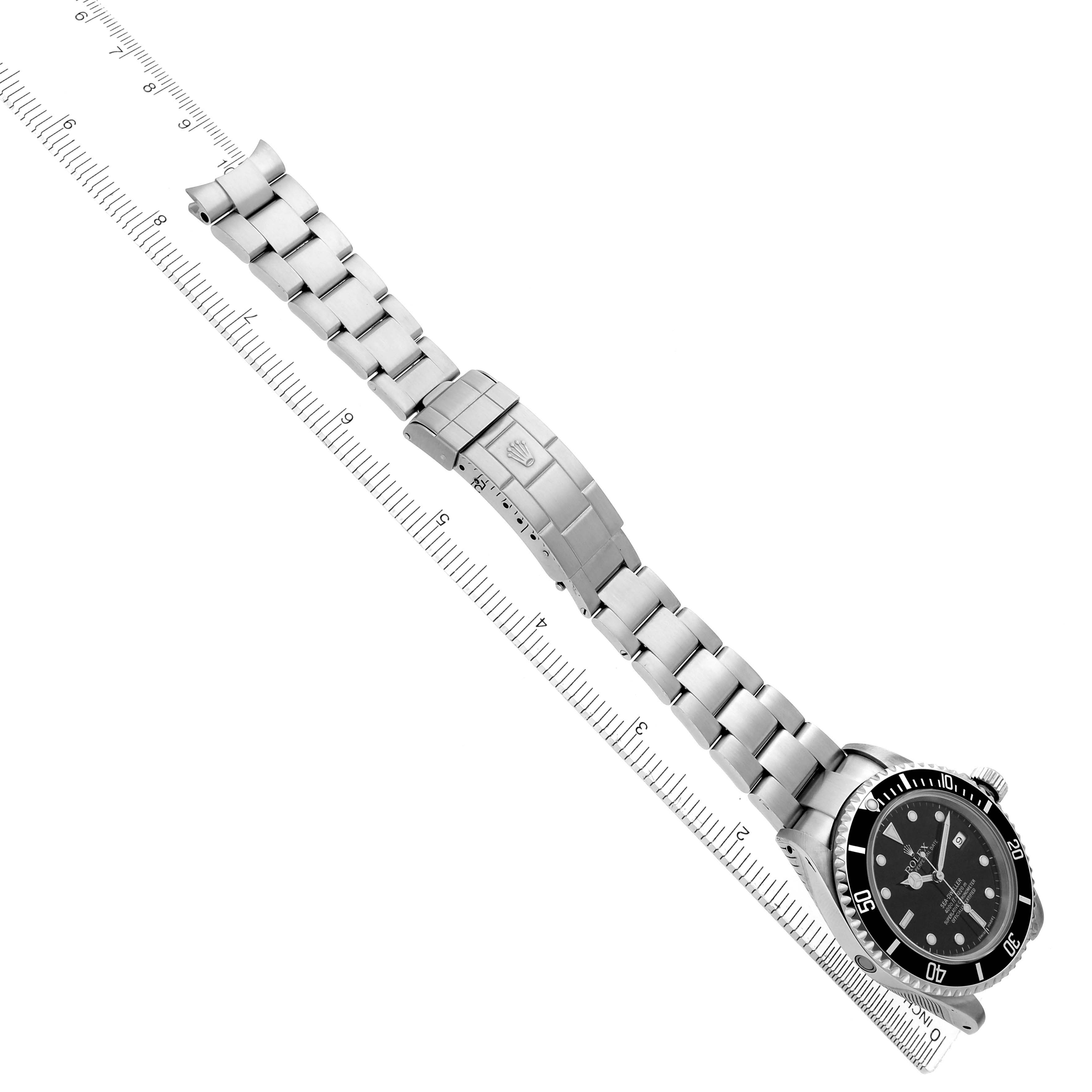 The Rolex Sea-Dweller 16600 Men
s Stainless Steel Black Dial 16600 Men
s Stainless Steel Black Dial watch is shown at an angle with its full bracelet, clasp, and case visible next to a ruler for scale.