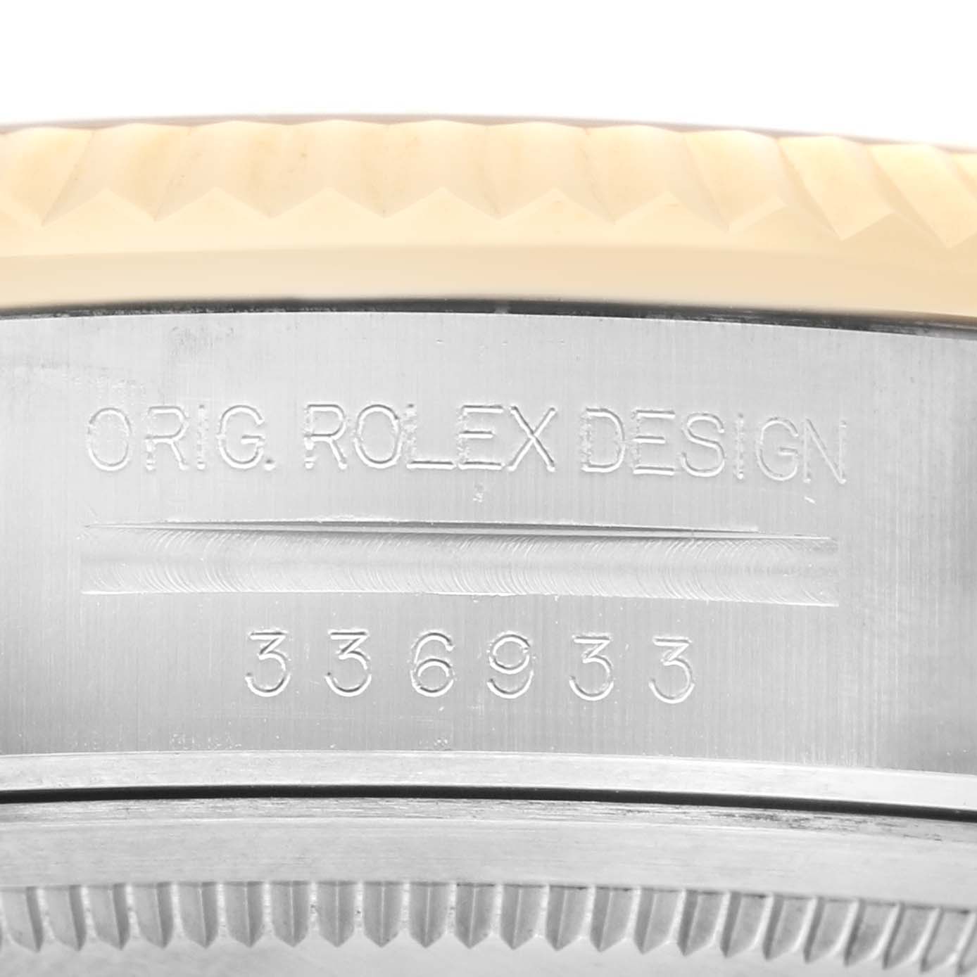 The image shows a close-up of the Rolex Sky-Dweller 336933 Men's Steel and Gold (two tone) Black Dial watch's side, featuring engravings and part of the fluted bezel.