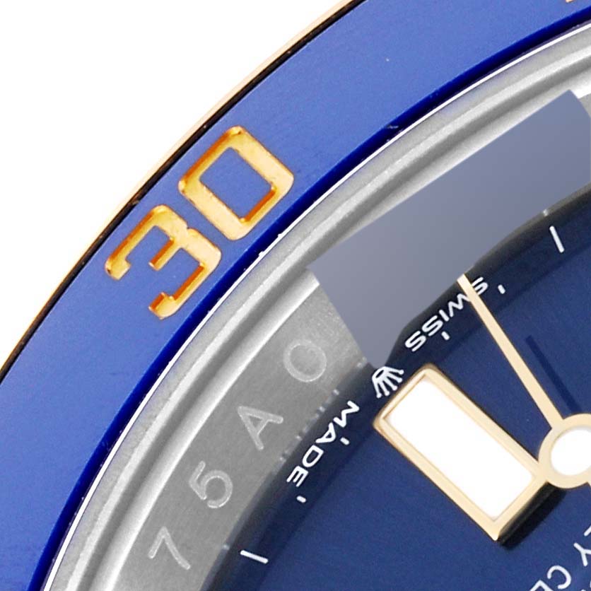 The image shows a close-up of a Rolex Submariner 126613 Men
s Steel and Gold (two tone) Blue Dial 126613 Men
s Steel and Gold (two tone) Blue Dial watch face, including the bezel, part of the dial, and hands.