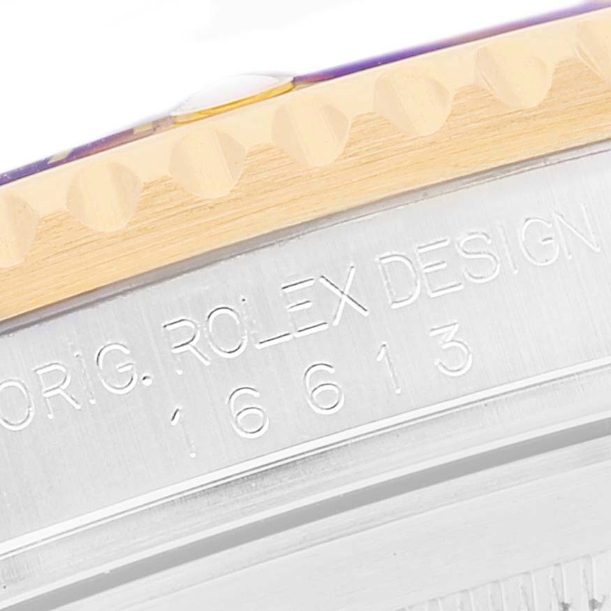 The image shows a close-up of the Rolex Submariner 16613 Men
s Steel and Gold (two tone) Blue Dial 16613 Men
s Steel and Gold (two tone) Blue Dial
s bezel and engraved model number.