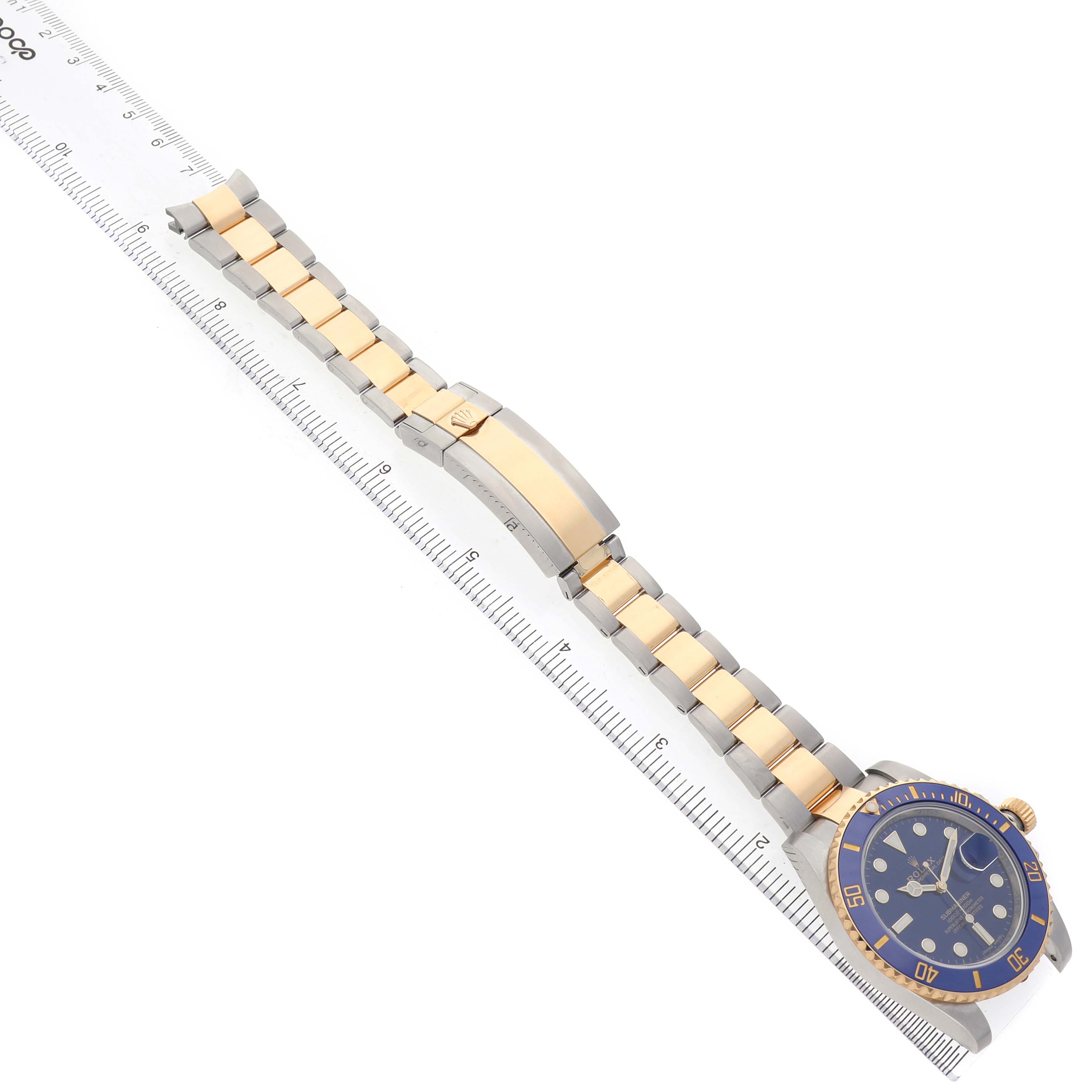 The Rolex Submariner 116613 Men's Steel and Gold (two tone) Blue Dial watch is shown from an overhead angle, featuring the face, bezel, bracelet, and clasp.