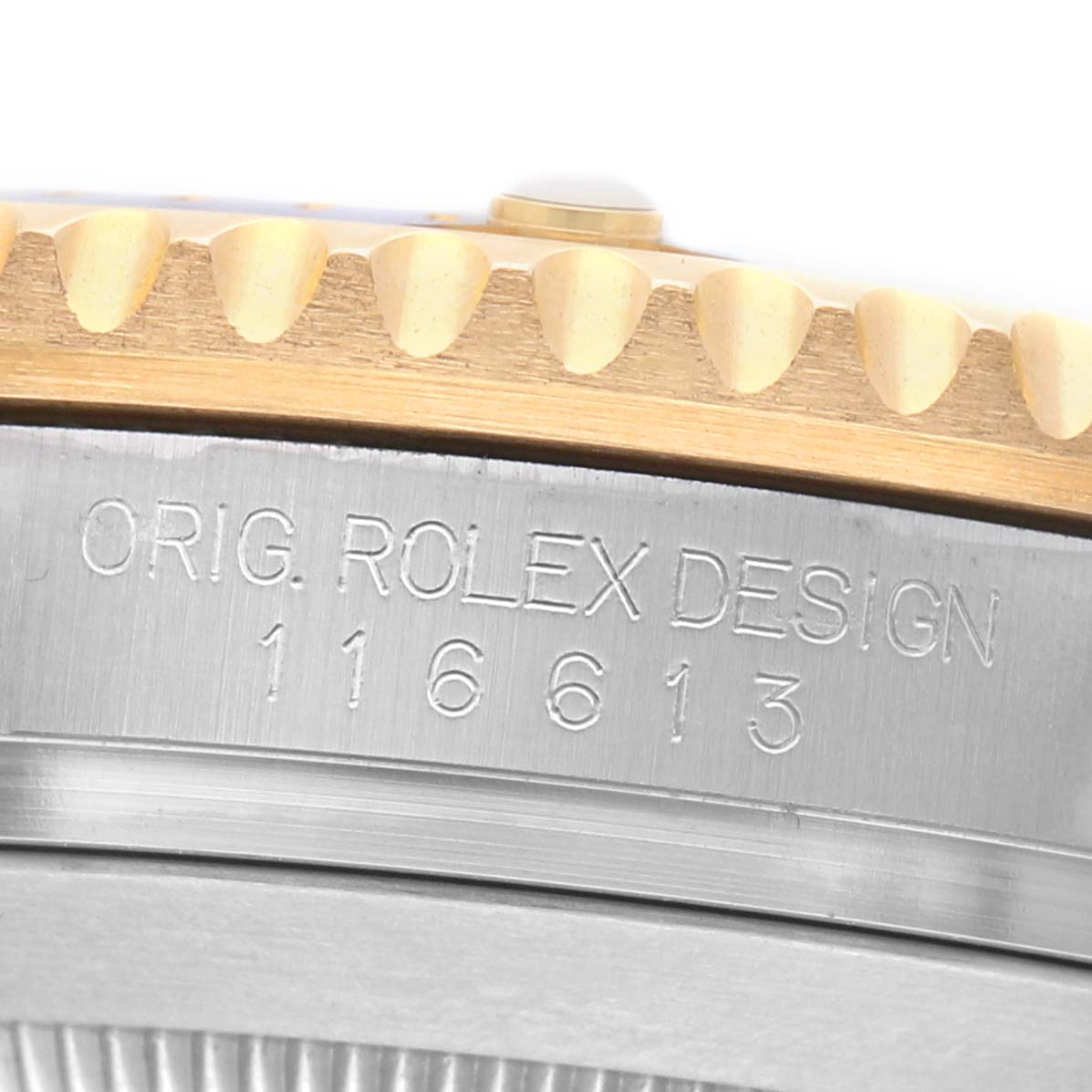 The image shows a close-up of the bezel edge and engraved case side of a Rolex Submariner 116613 Men's Steel and Gold (two tone) Blue Dial, model number 116613.