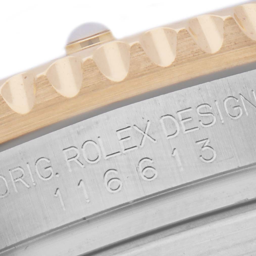 The image shows a close-up of the fluted bezel and engraved edge of a Rolex Submariner 116613 Men's Steel and Gold (two tone) Blue Dial 116613 Men's Steel and Gold (two tone) Blue Dial watch.