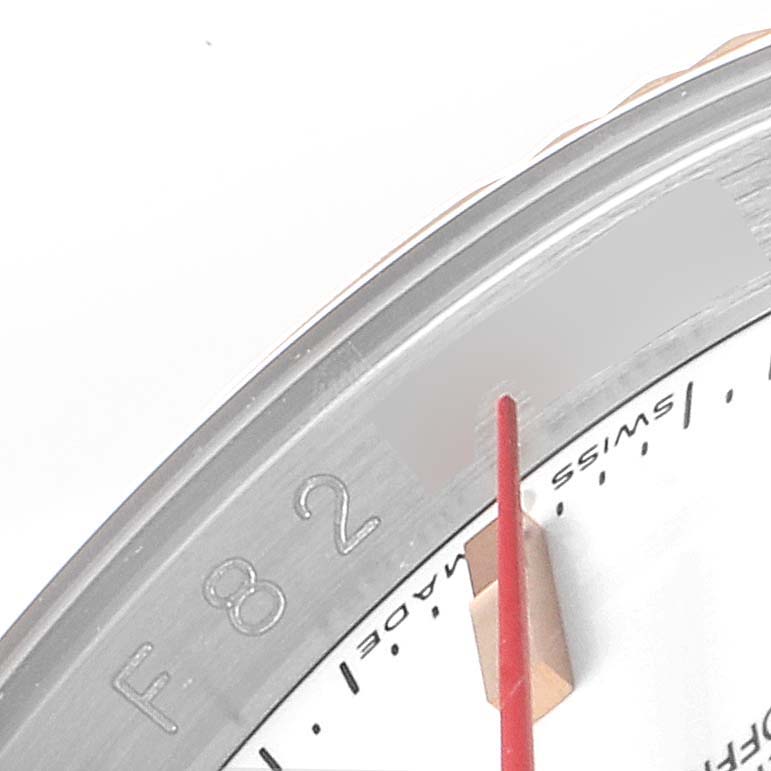 This close-up image of the Rolex Turn-o-Graph 116261 Men
s Steel and Gold (two tone) White Dial 116261 Men
s Steel and Gold (two tone) White Dial watch shows part of the bezel, red seconds hand, and a portion of the dial.