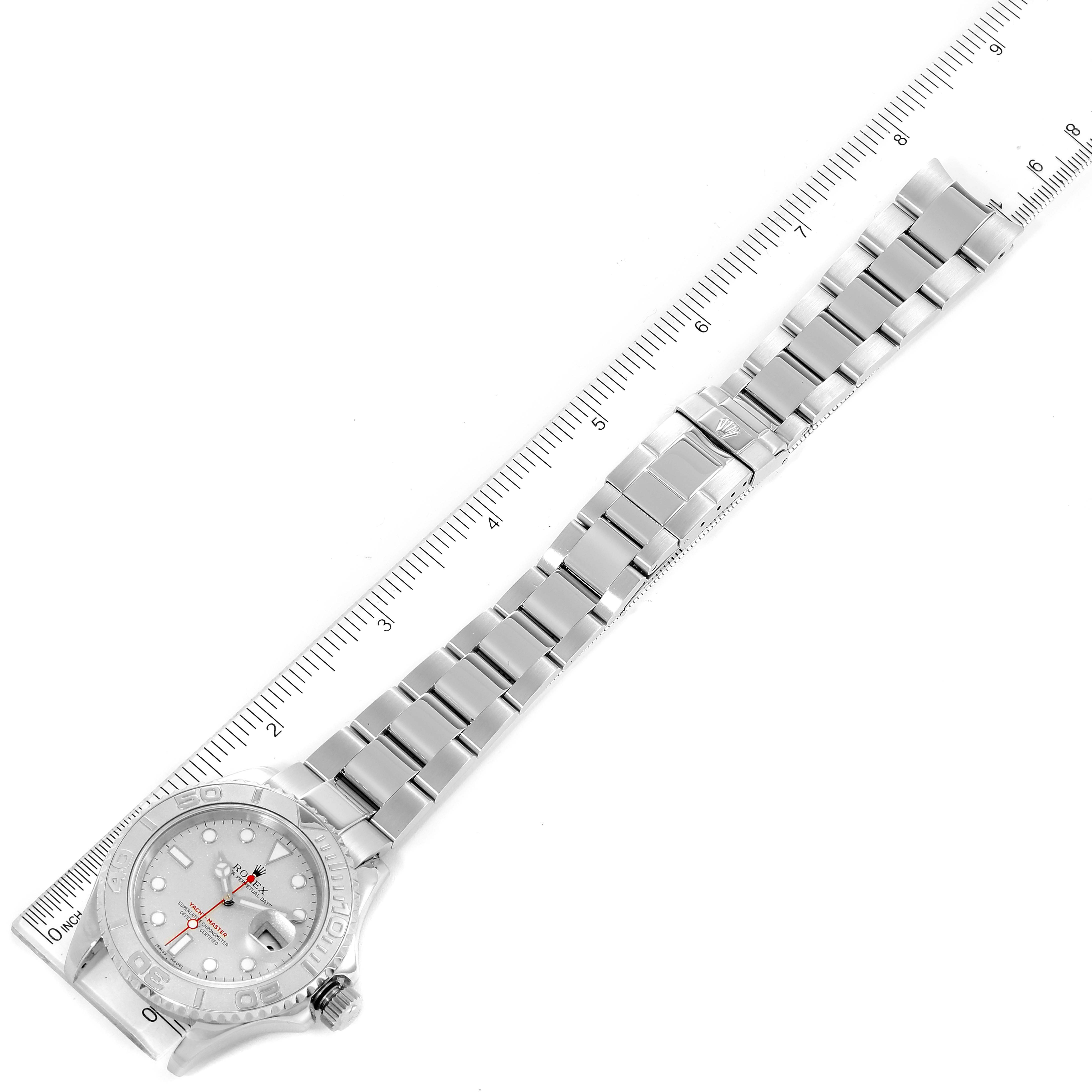 This image shows a top view of a Rolex Yacht-Master 16622 Men's Stainless Steel Silver Dial 16622 Men's Stainless Steel Silver Dial watch with its face, bezel, bracelet, and clasp alongside a measuring ruler.