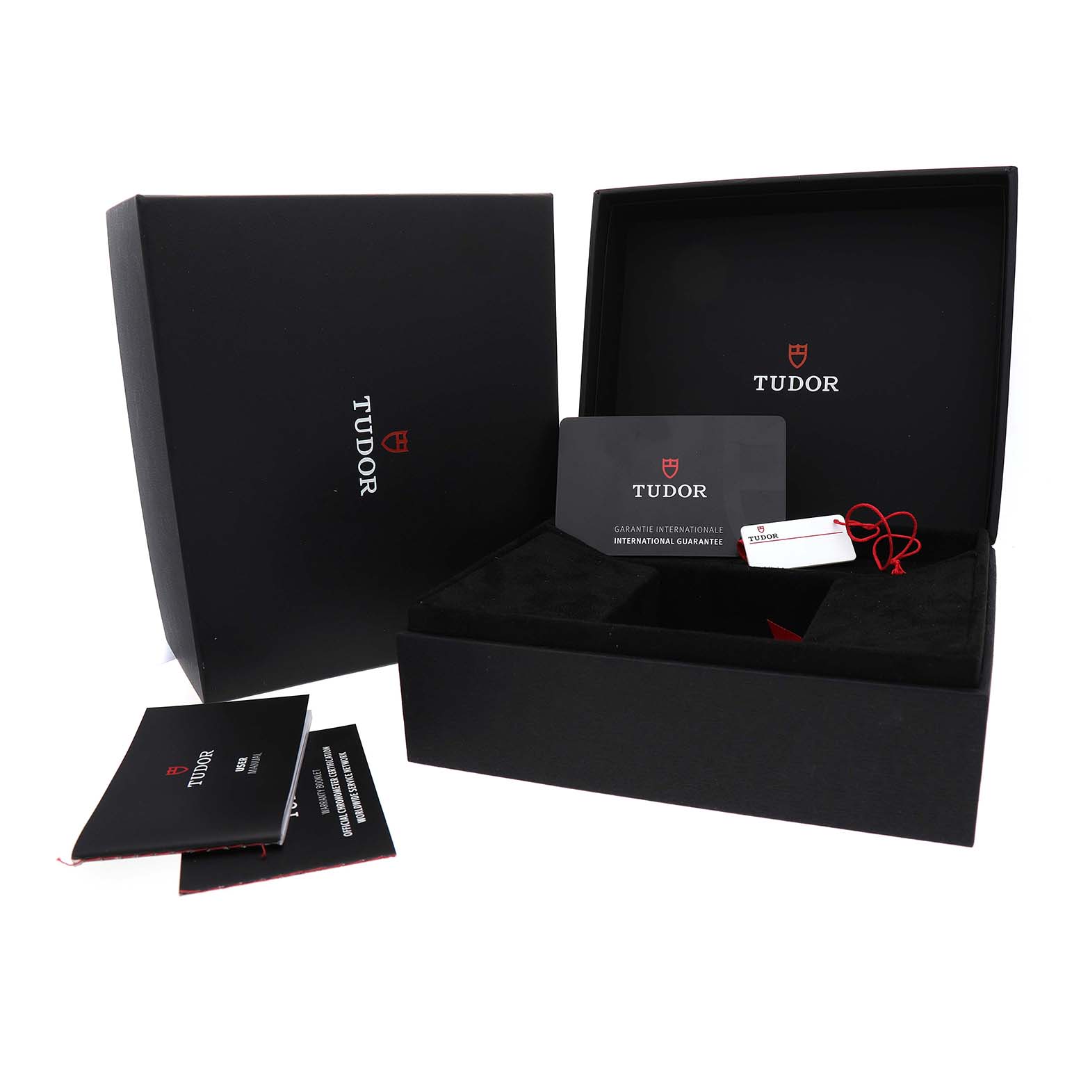 The image shows the packaging for the Tudor Heritage Black Bay 7943A1A0NU Men's Stainless Steel Silver Dial, including an open box, warranty card, and tags.