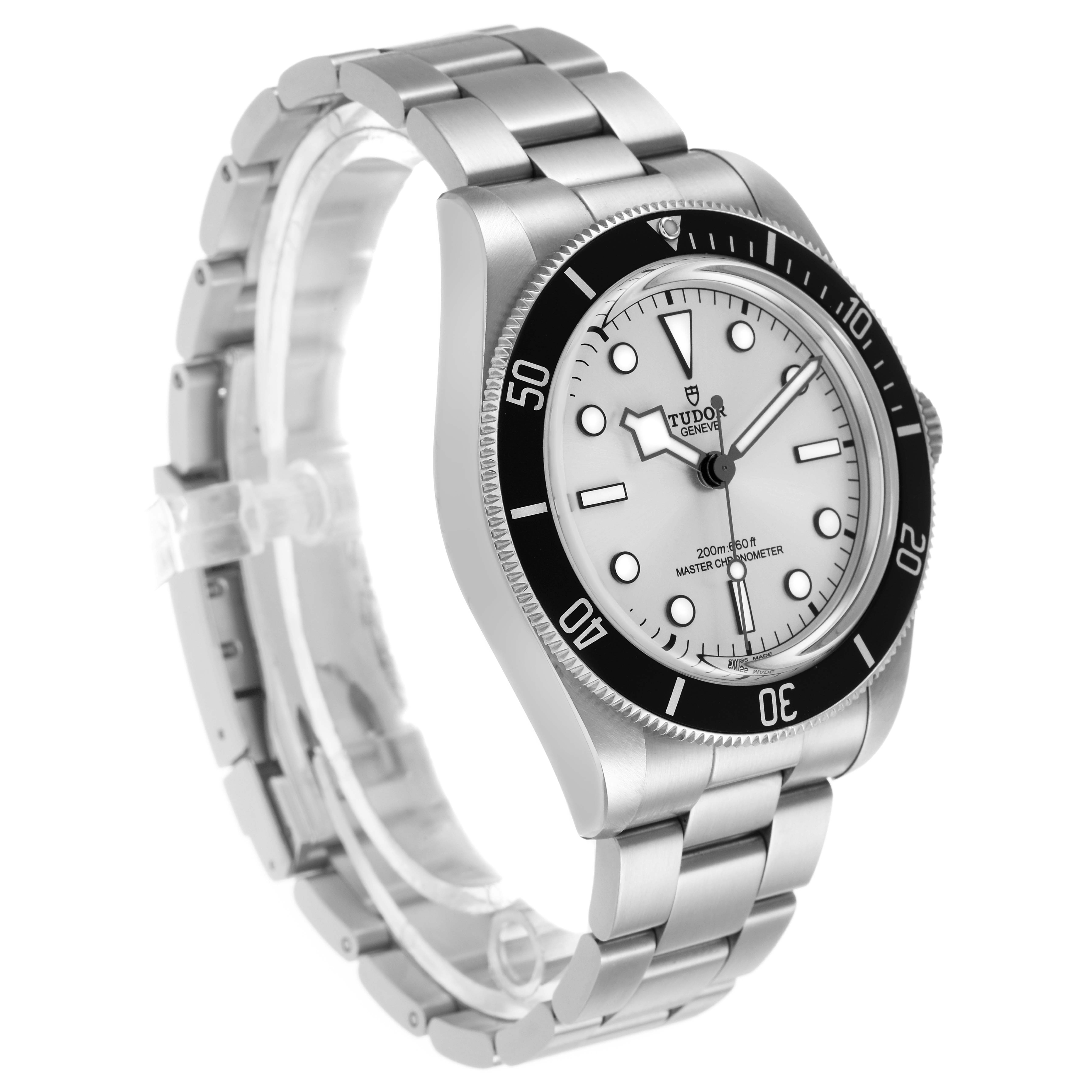 The Tudor Heritage Black Bay 7943A1A0NU Men's Stainless Steel Silver Dial watch is shown from a three-quarter angle, highlighting the face, bezel, and bracelet.