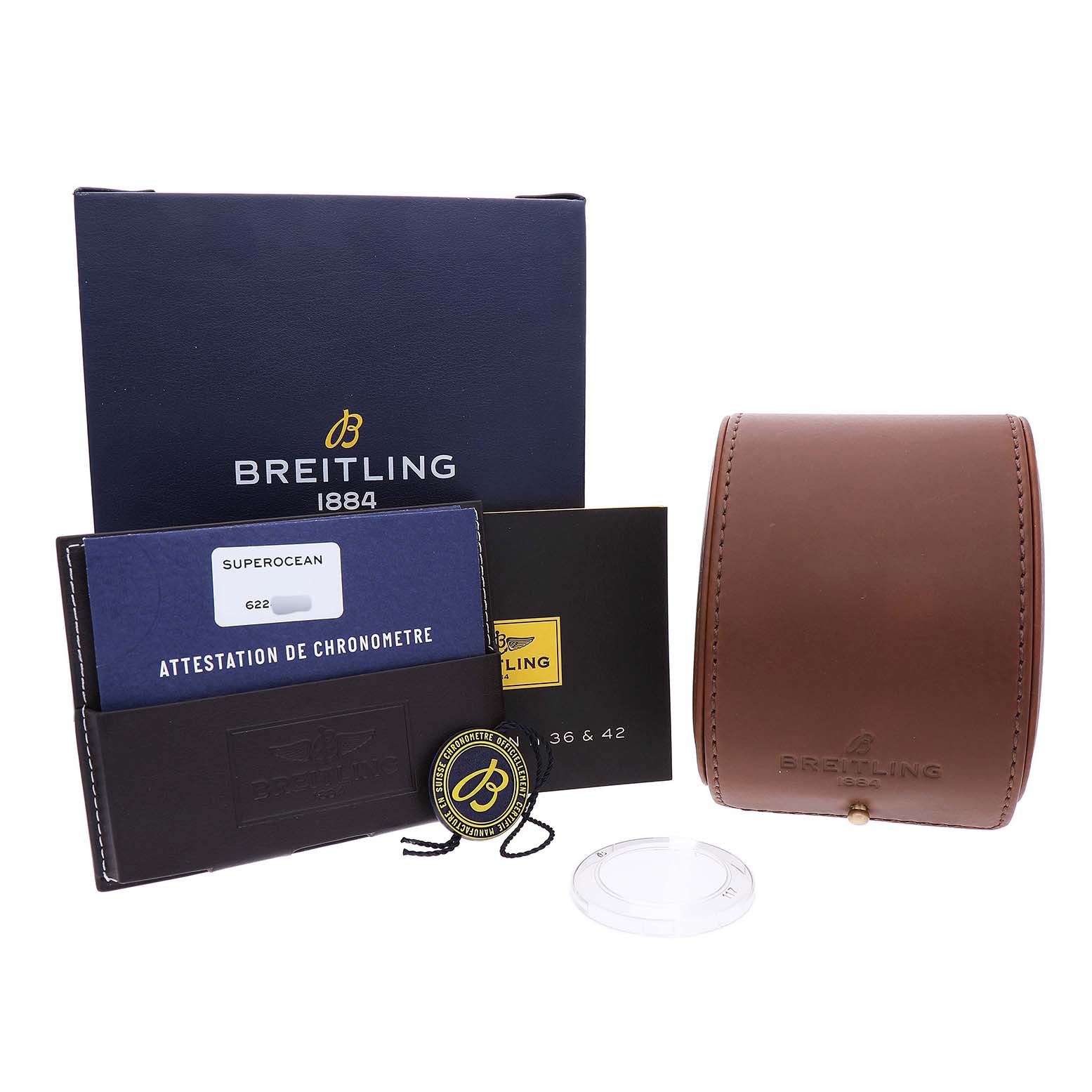 The Breitling Superocean A17365 Men's Stainless Steel Black Dial accessories include a blue box, brown leather case, certificate, and a badge, all shown from the front.