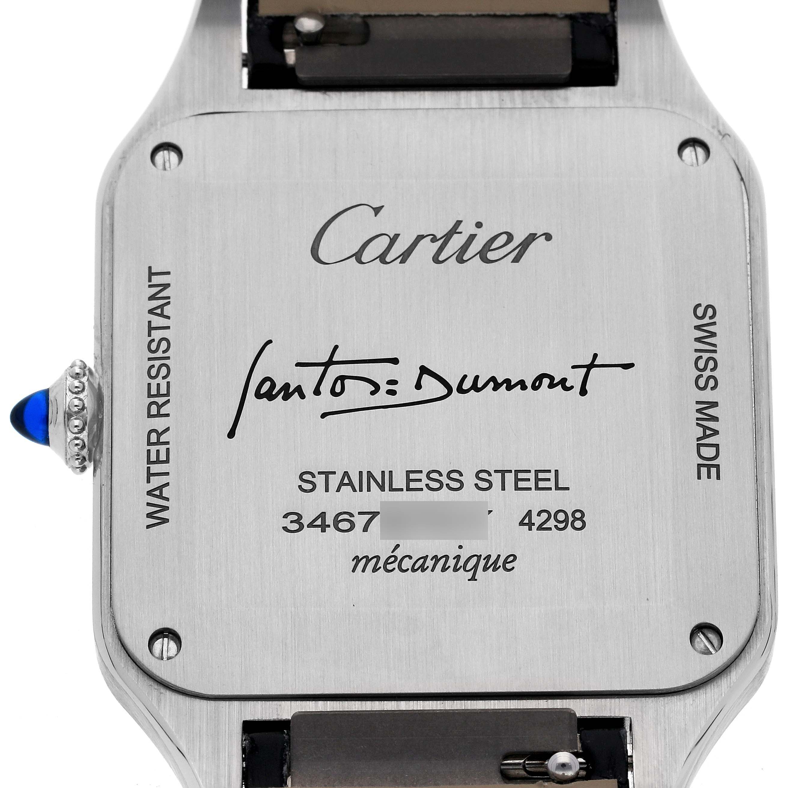 The image shows the back case of a Cartier Santos Dumont WSSA0046 Men's Stainless Steel Black Dial WSSA0046 Men's Stainless Steel Black Dial watch, highlighting engravings and the crown with a blue gemstone.