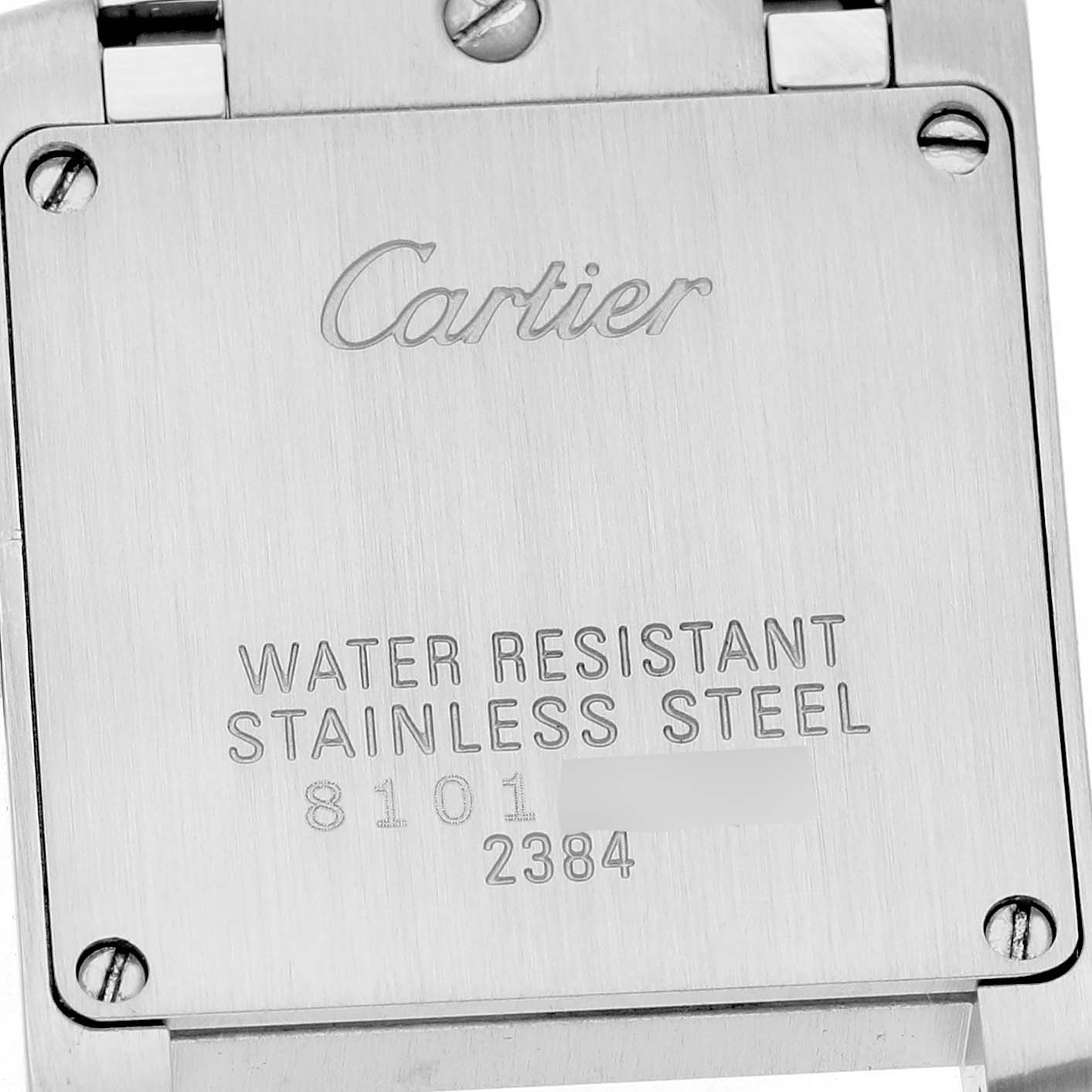 The image shows the stainless steel back case of a Cartier Tank Française watch with engraved details.
