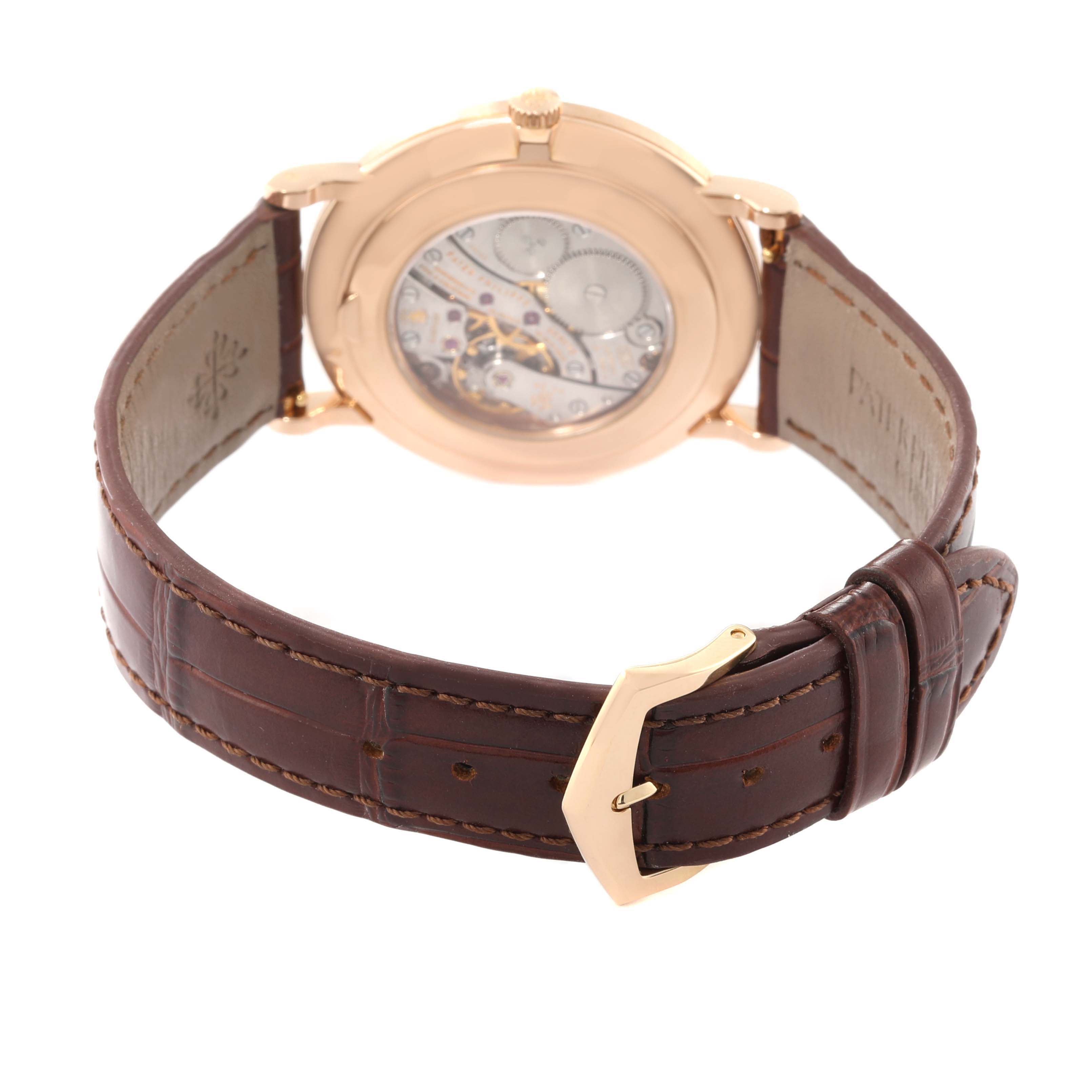 The image shows the back view of a Patek Philippe Calatrava 5119R Men's Rose Gold White Dial 5119R Men's Rose Gold White Dial watch, highlighting its movement and brown leather strap.