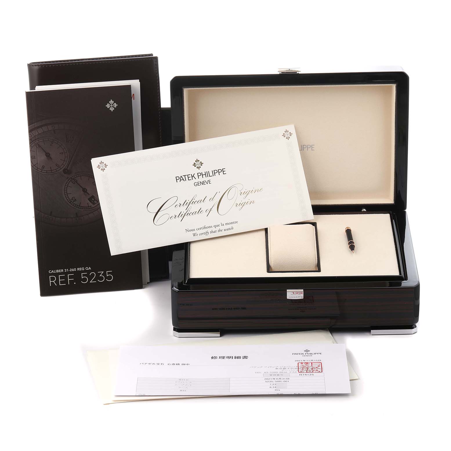 The image shows a Patek Philippe Complications 5235/50R-001 Men
s Rose Gold Black Dial 5235/50R-001 Men
s Rose Gold Black Dial box at a slight angle, displaying documentation and a certificate of origin.
