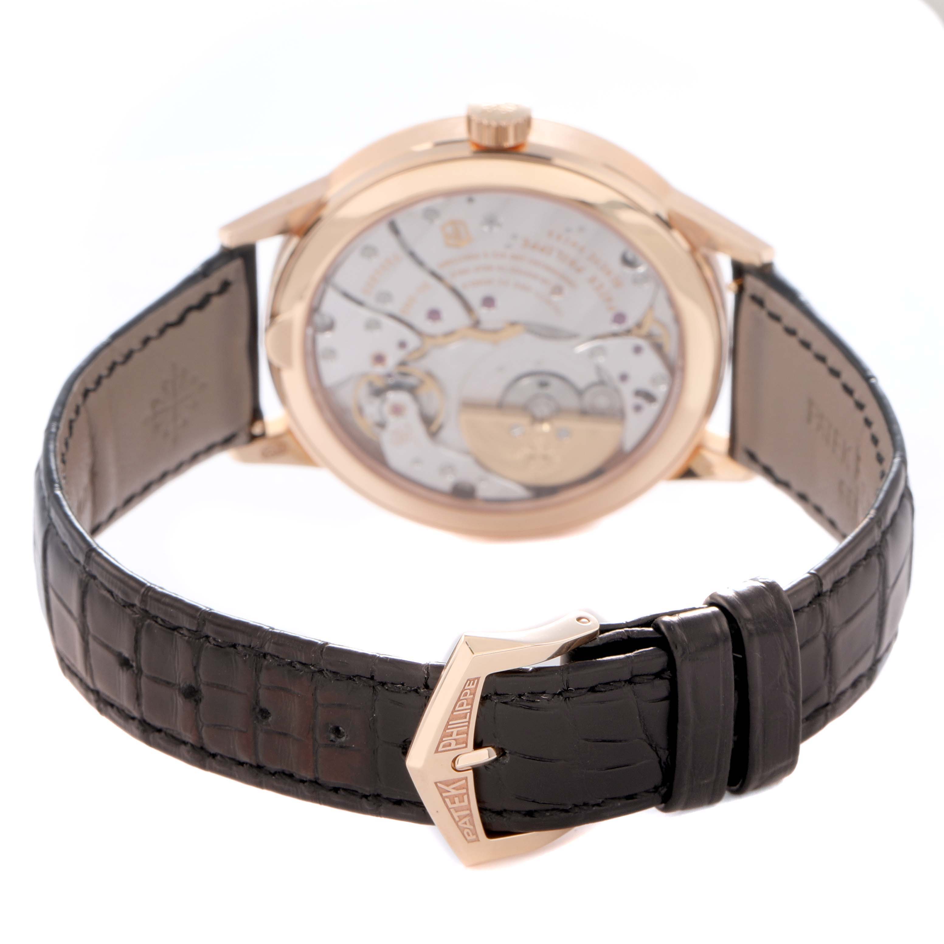 The Patek Philippe Complications 5235/50R-001 Men
s Rose Gold Black Dial 5235/50R-001 Men
s Rose Gold Black Dial watch is shown from the rear, highlighting its movement and a dark leather strap with a branded clasp.
