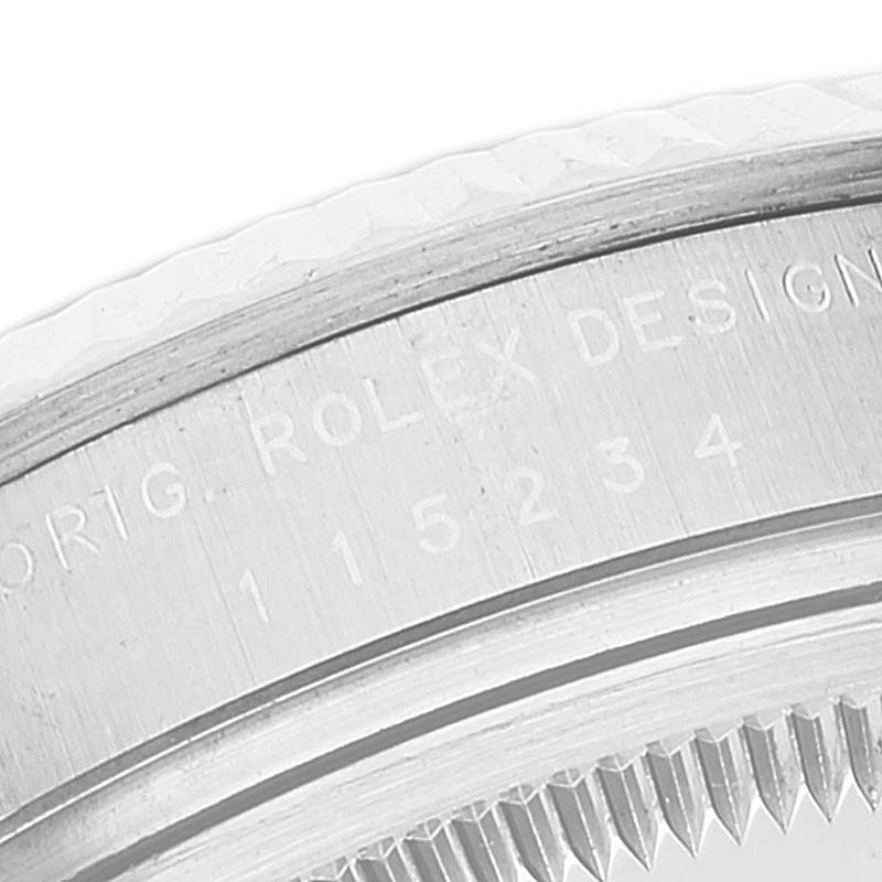 This is a close-up of the serial number on the bezel and case of a Rolex Date 115234 Men's Stainless Steel Black Dial 115234 Men's Stainless Steel Black Dial watch.