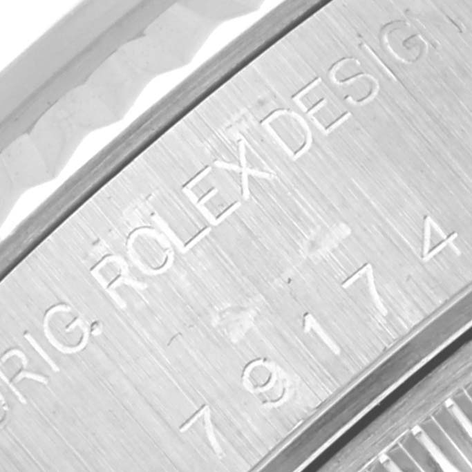 The image shows a close-up of the serial number and "Rolex Design" inscription on the side of a Rolex Datejust 79174 Women
s Stainless Steel Silver Dial 79174 Women
s Stainless Steel Silver Dial watch case.