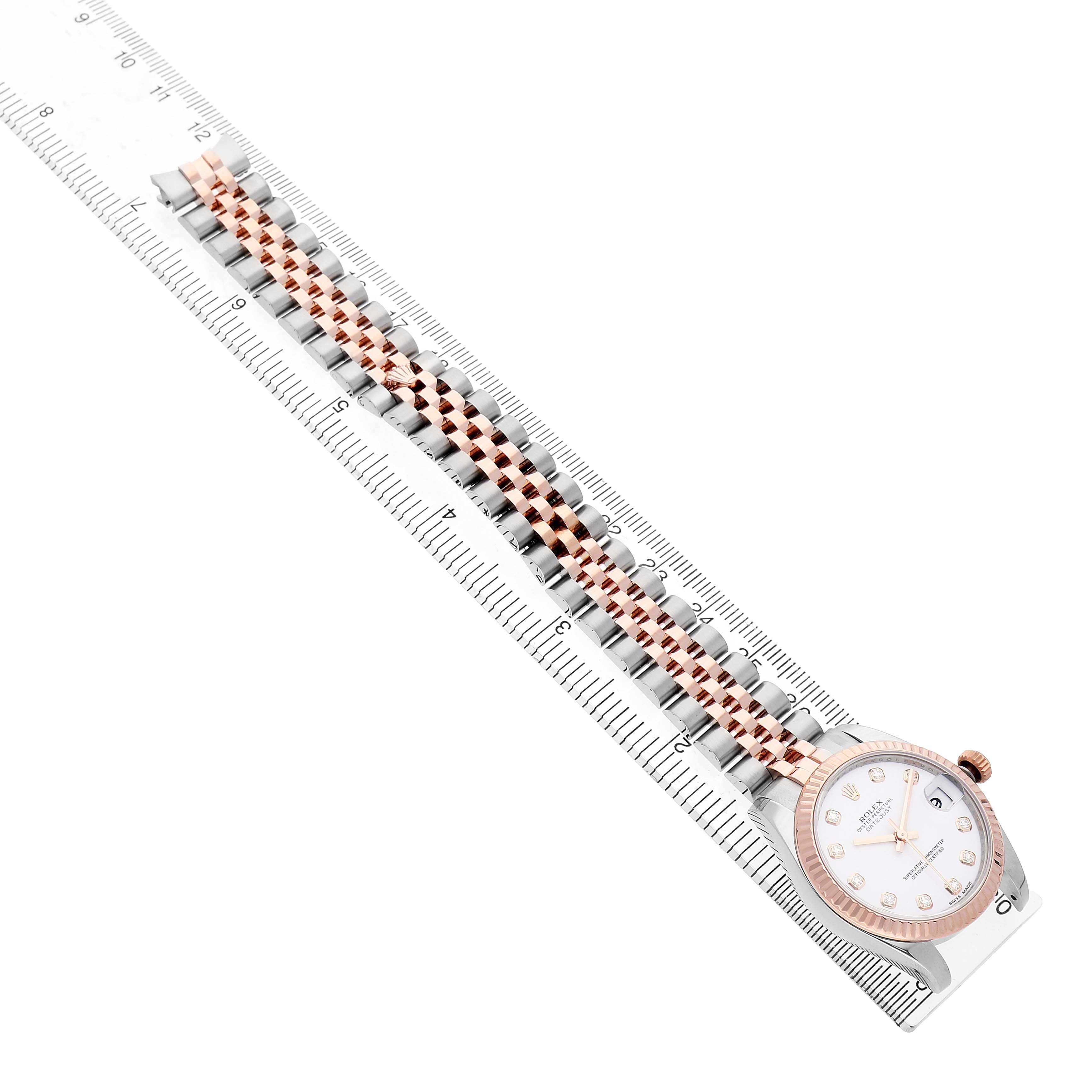 The Rolex Mid-Size 178271 Women's Steel and Gold (two tone) White Dial watch is shown at a side angle, highlighting the face, bezel, and bracelet along a ruler for scale.
