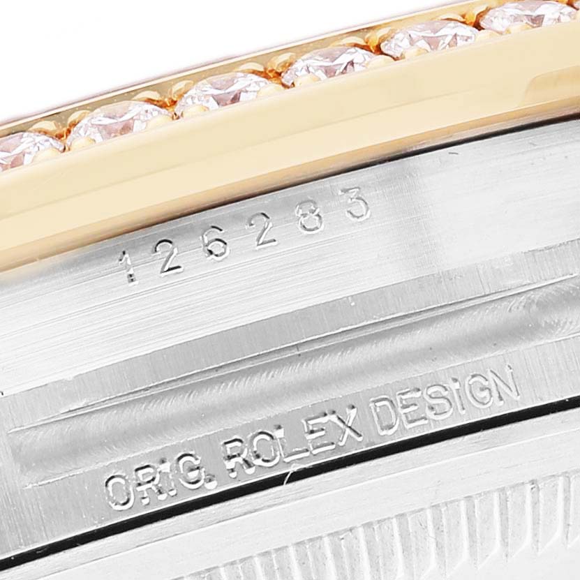 The image shows a close-up of the Rolex Datejust 126283 Women's Steel and Gold (two tone) Green Dial's engraved serial number and bezel with diamonds.