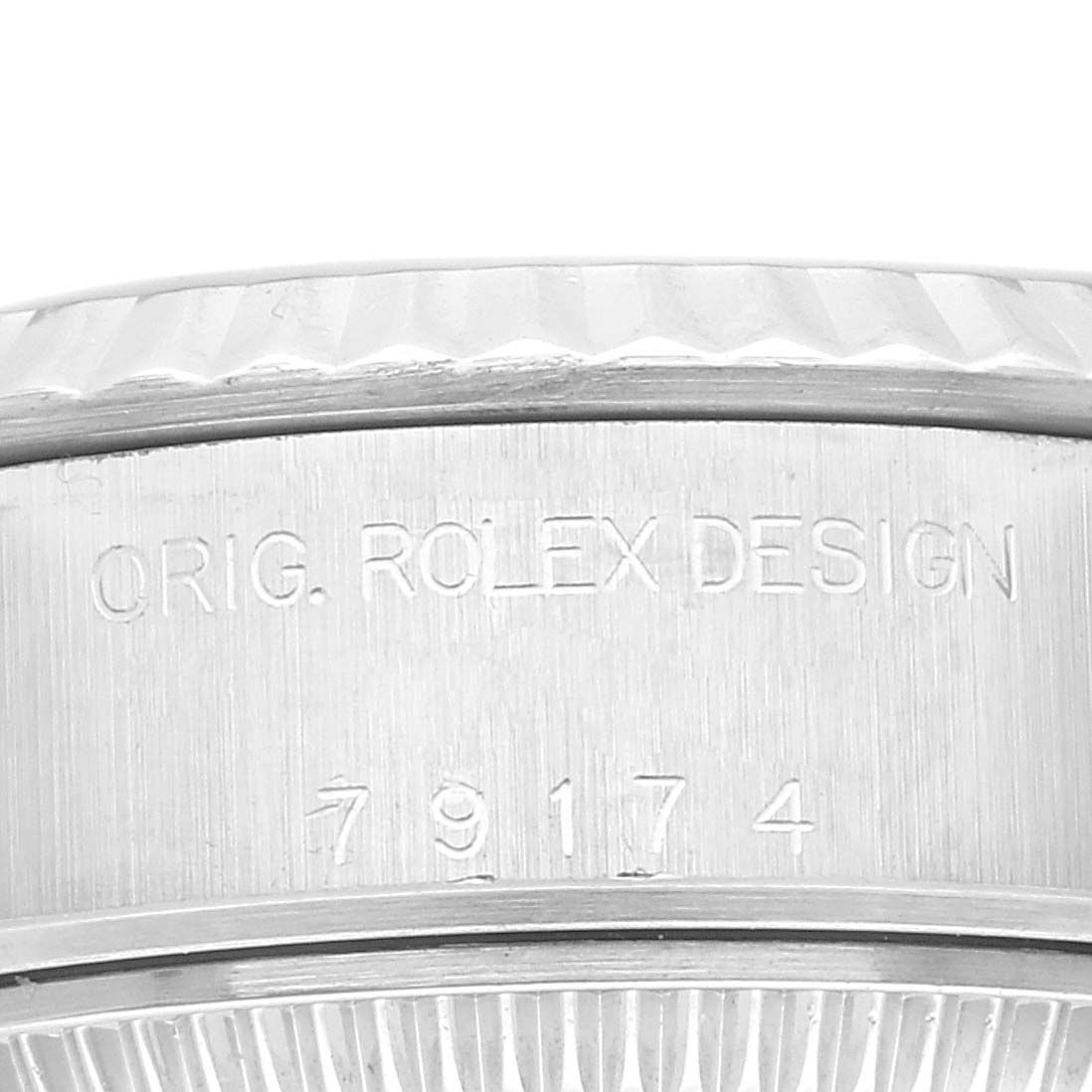 This is a close-up view of the side of a Rolex Datejust 79174 Women's Stainless Steel Blue Dial 79174 Women's Stainless Steel Blue Dial watch, showcasing the engraved "ORIG. ROLEX DESIGN" and model number "79174".