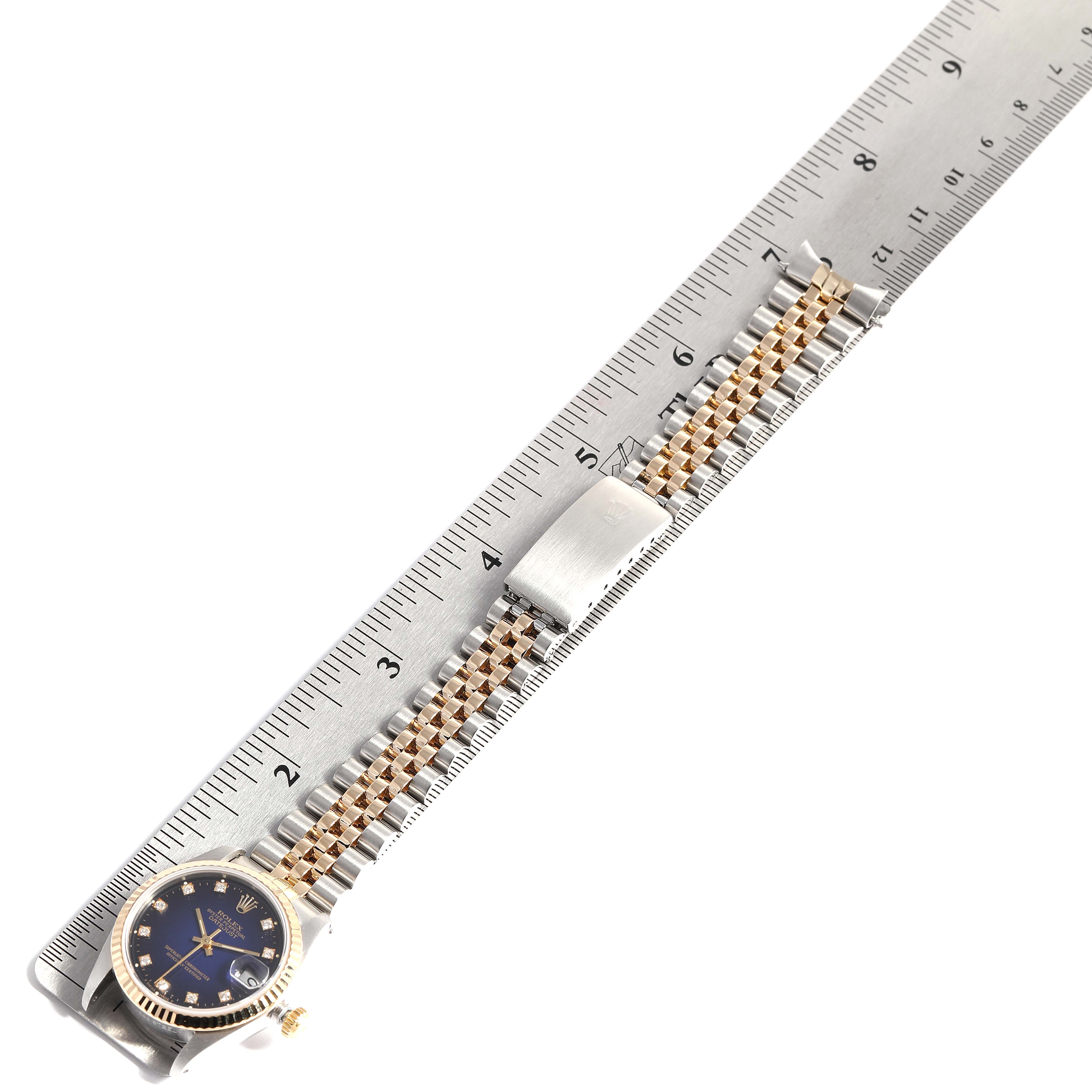 The image shows a side view of a Rolex Datejust 68273 Women's Steel and Gold (two tone) Blue Dial 68273 Women's Steel and Gold (two tone) Blue Dial watch with a two-tone bracelet placed alongside a ruler.