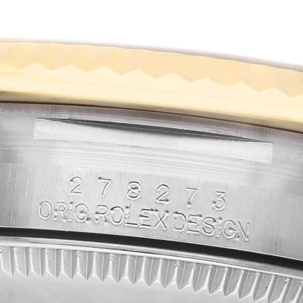 The image shows a close-up of the side of a Rolex Mid-Size 278273 Women's Steel and Gold (two tone) White Dial watch case with engraved details.