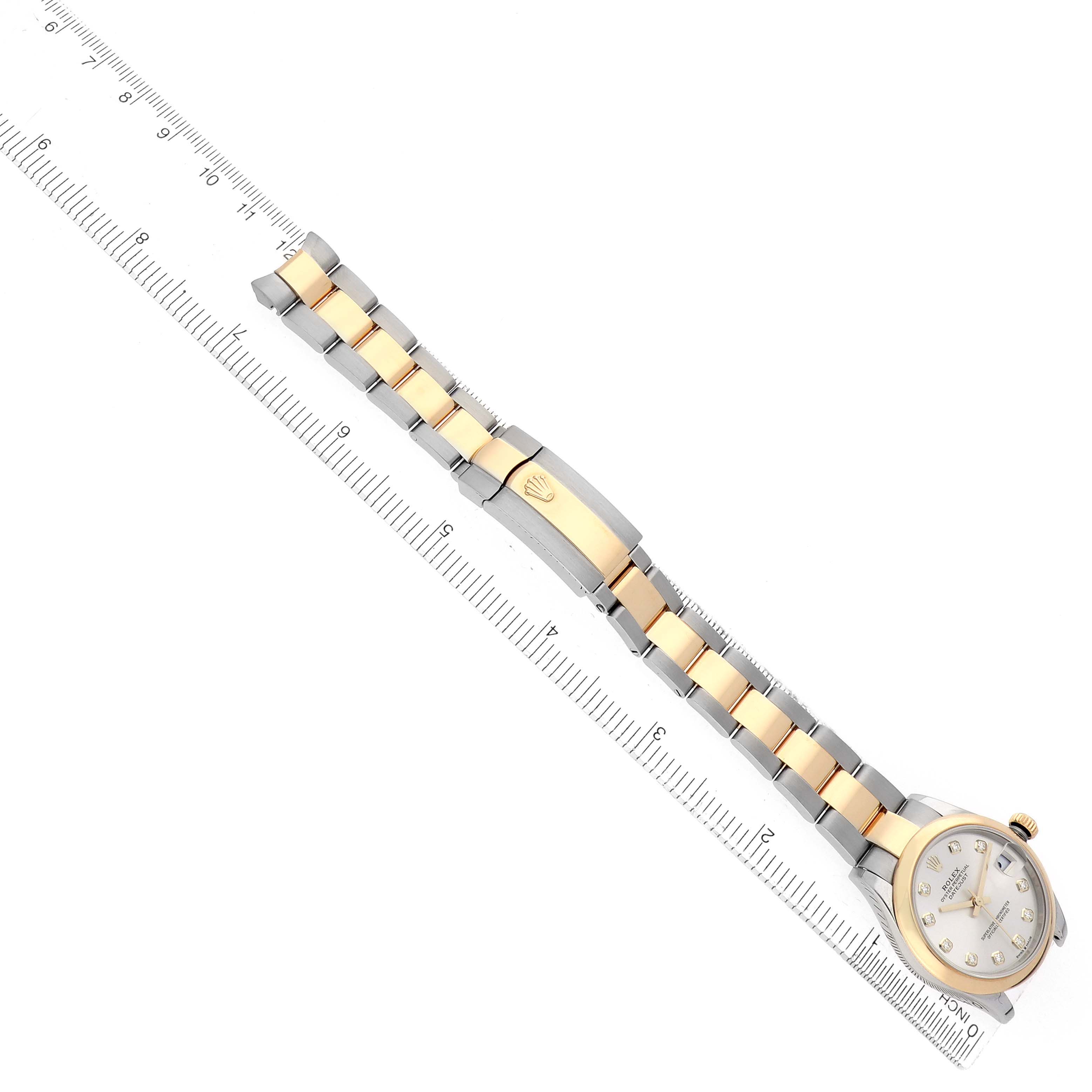 The image shows a Rolex Mid-Size 278243 Women's Steel and Gold (two tone) Silver Dial watch from a top view, highlighting the face, bracelet, and clasp on a ruler for scale.