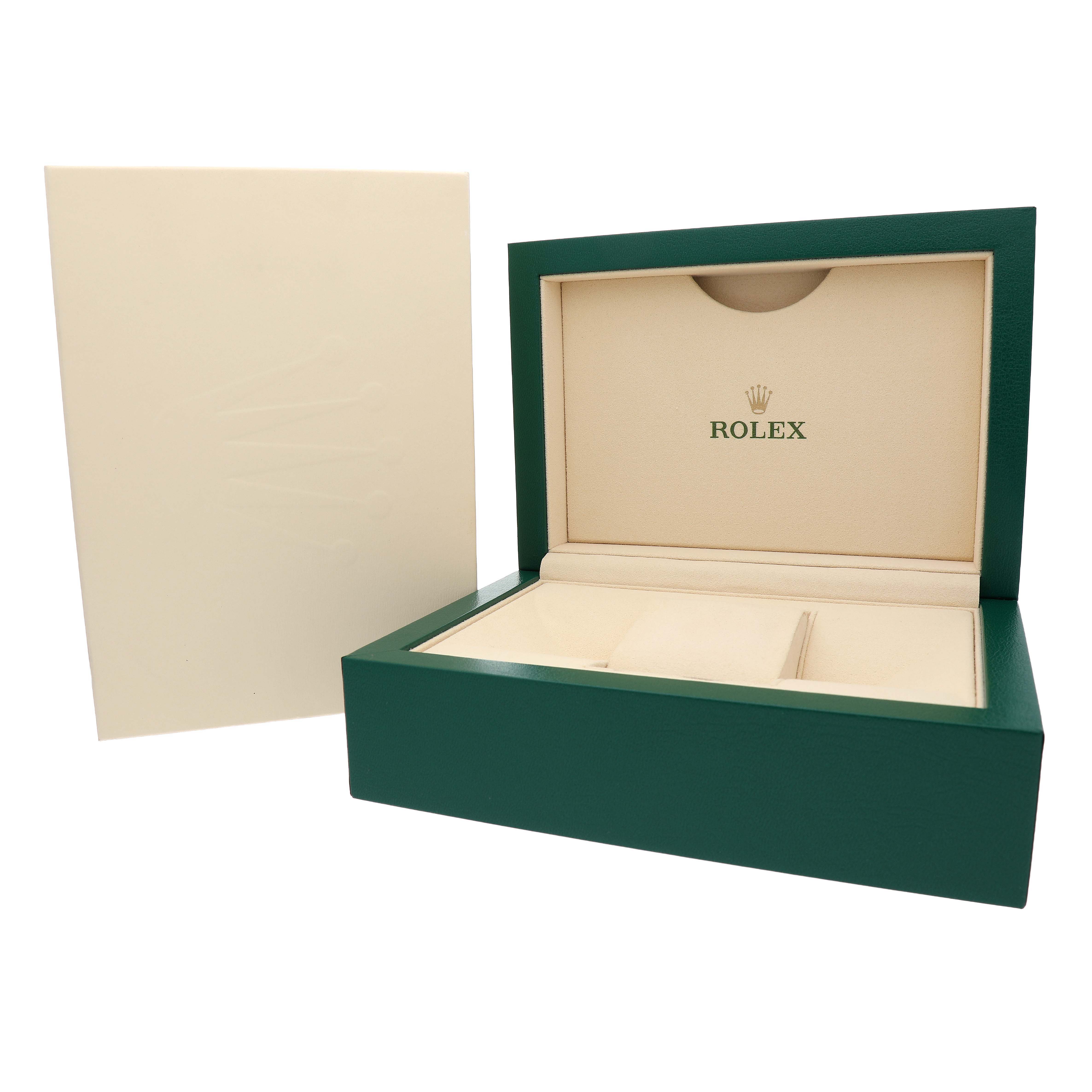 This image shows a Rolex watch box open, angled to reveal the interior compartments and branding.