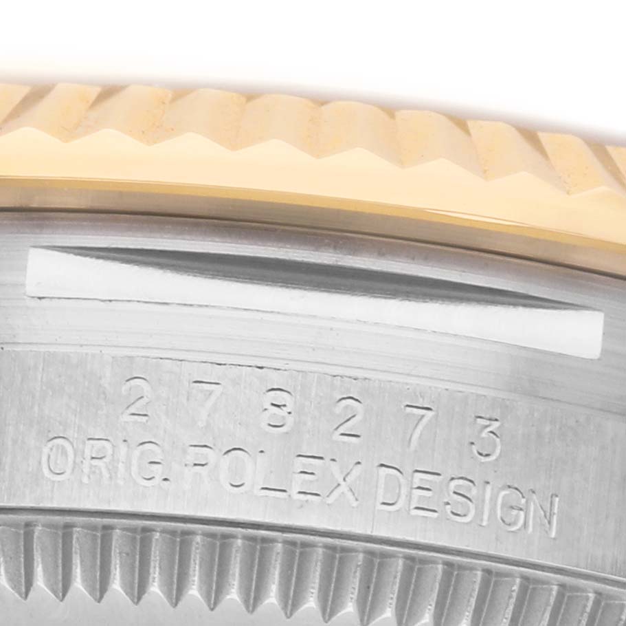 This close-up image shows the side of a Mid-Size Rolex watch, highlighting the engraved serial number and part of the bezel.